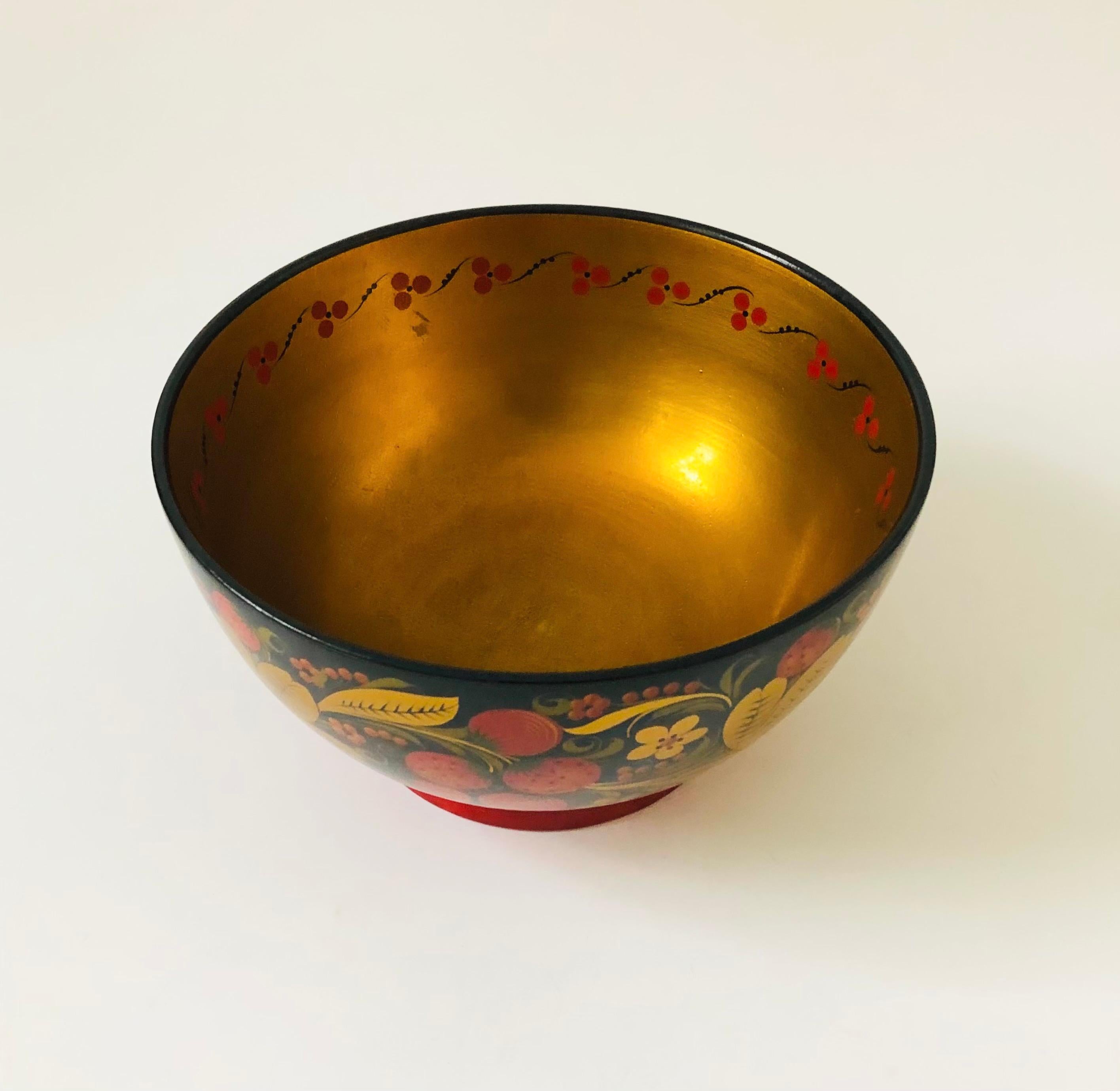 A beautiful vintage Russian Khokhloma lacquerware bowl. Made of wood with a colorful hand painted and lacquered floral design in gold, red, and black. Original sticker is still attached and printed 