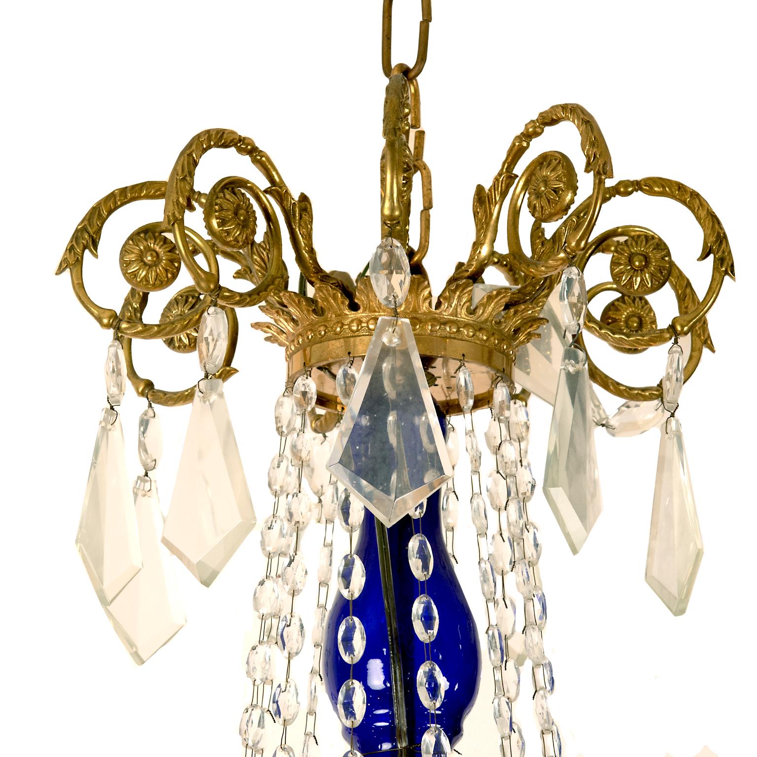 This magnificent large gilt bronze (ormolu) chandelier is decorated with clear crystal drops and cobalt blue glass bobeche, column and decorative hanging ball. It comes from a magnificent home in Toronto’s
the Bridal Path neighborhood. It is wired