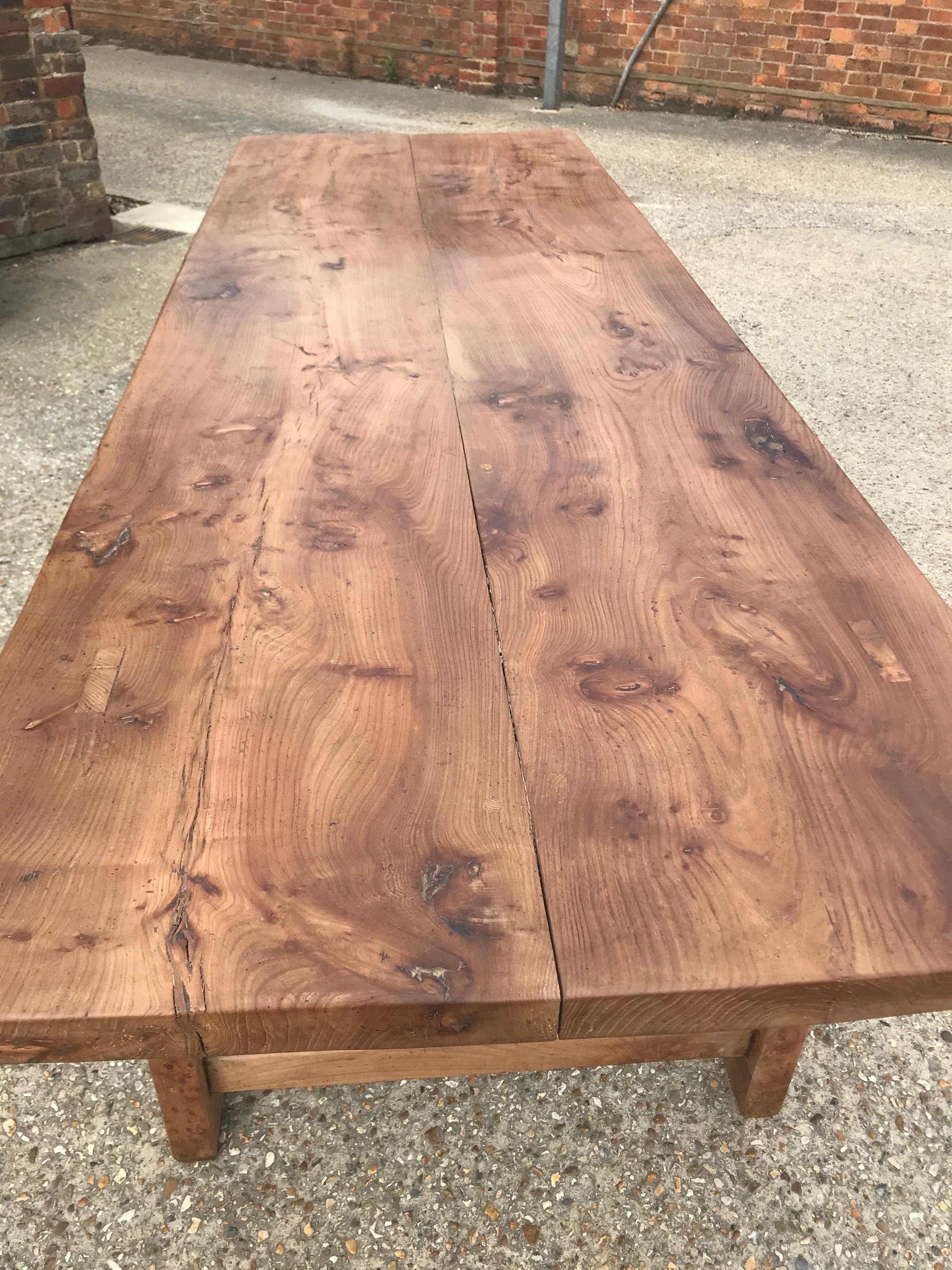 Large rustic elm French farmhouse table early 20th century. Stunning figured two plank top and stands on four sturdy legs with end stretcher. Beautiful color and patina. 

Measurements:
H 30in (76.2cm)
W 37.5in (95.3cm)
L 112in
