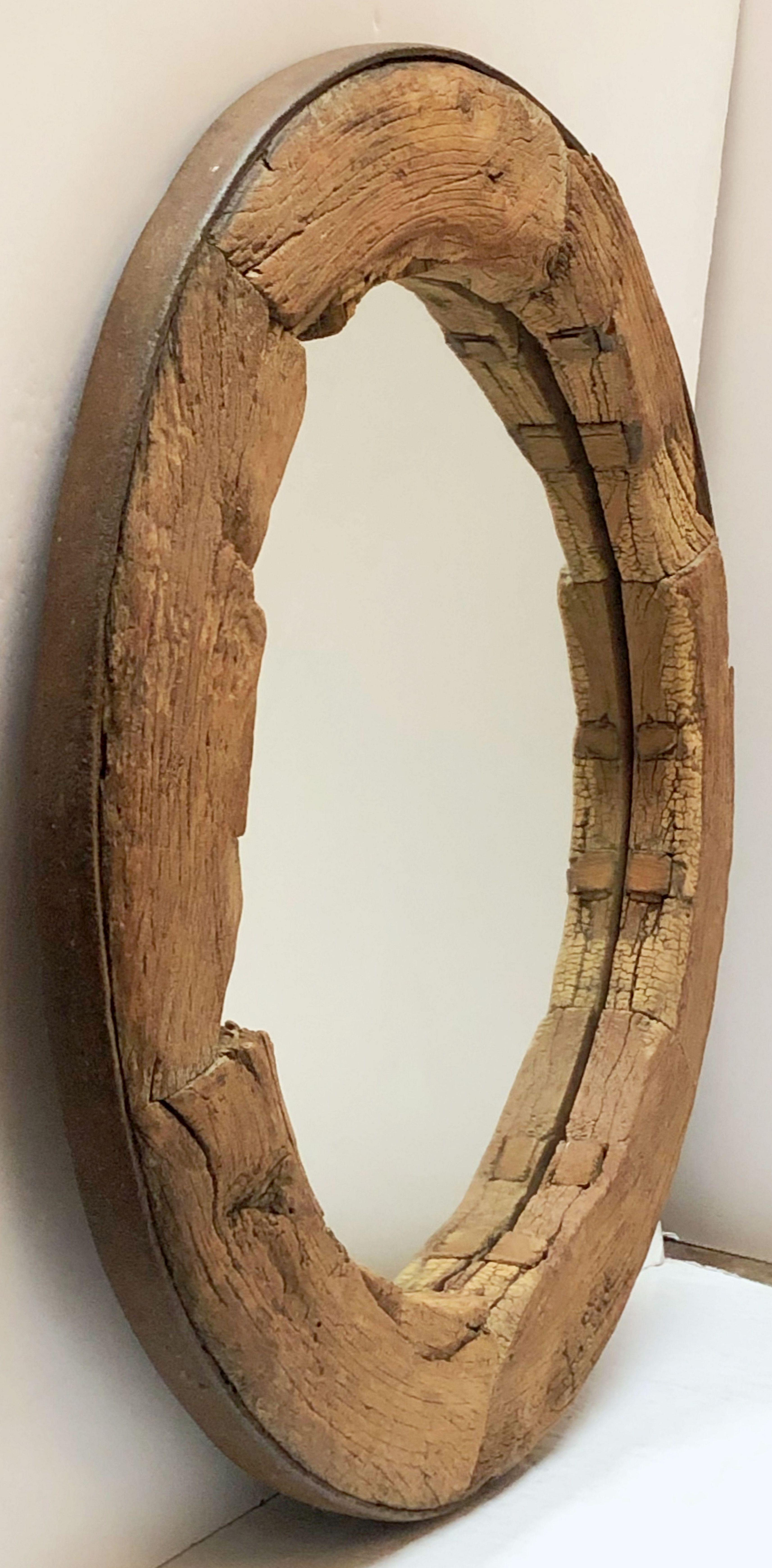 A handsome large rustic or Primitive English round or circular mirror with a frame fashioned from a wagon wheel of iron-bound oak 

Dimensions: Diameter 43 inches x Depth 4 inches