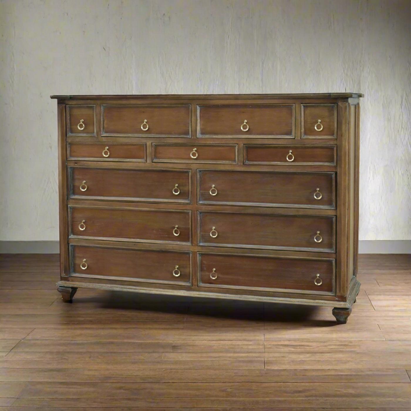 Realizzato in mogano massiccio, con la nostra calda finitura paglierina che mette in risalto la bellezza naturale delle venature del legno.

Con tredici cassetti spaziosi, ognuno dei quali ornato da tiretti dorati, il comò offre un ampio spazio per
