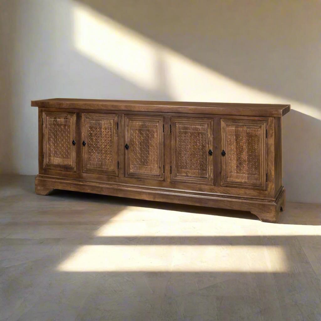 This grand statement piece effortlessly blends function with aesthetics, offering ample storage behind its four hand-carved doors. Each carving is unique, ensuring a one-of-a-kind masterpiece that adds character to your space.  

Designed for both