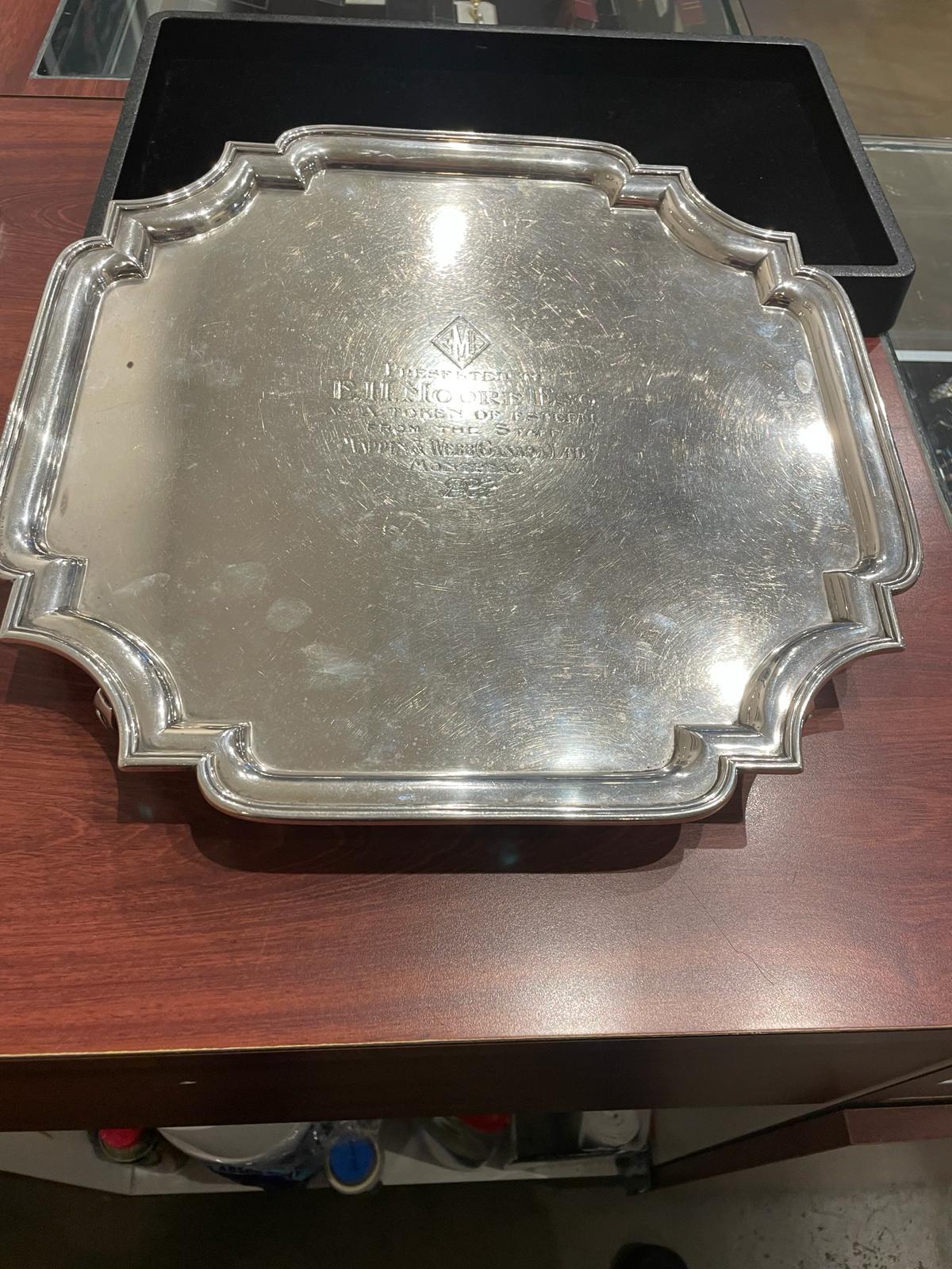 Large hallmarked sterling silver canted stepped edge salver, 

Bearing an inscription 

“Presented to E H Moore Esq 

as a token of esteem from the staff 

at Mappin & Webb Canada (Montreal)”

 

Marked for Sheffield 1923

On scroll feet

 

Approx.