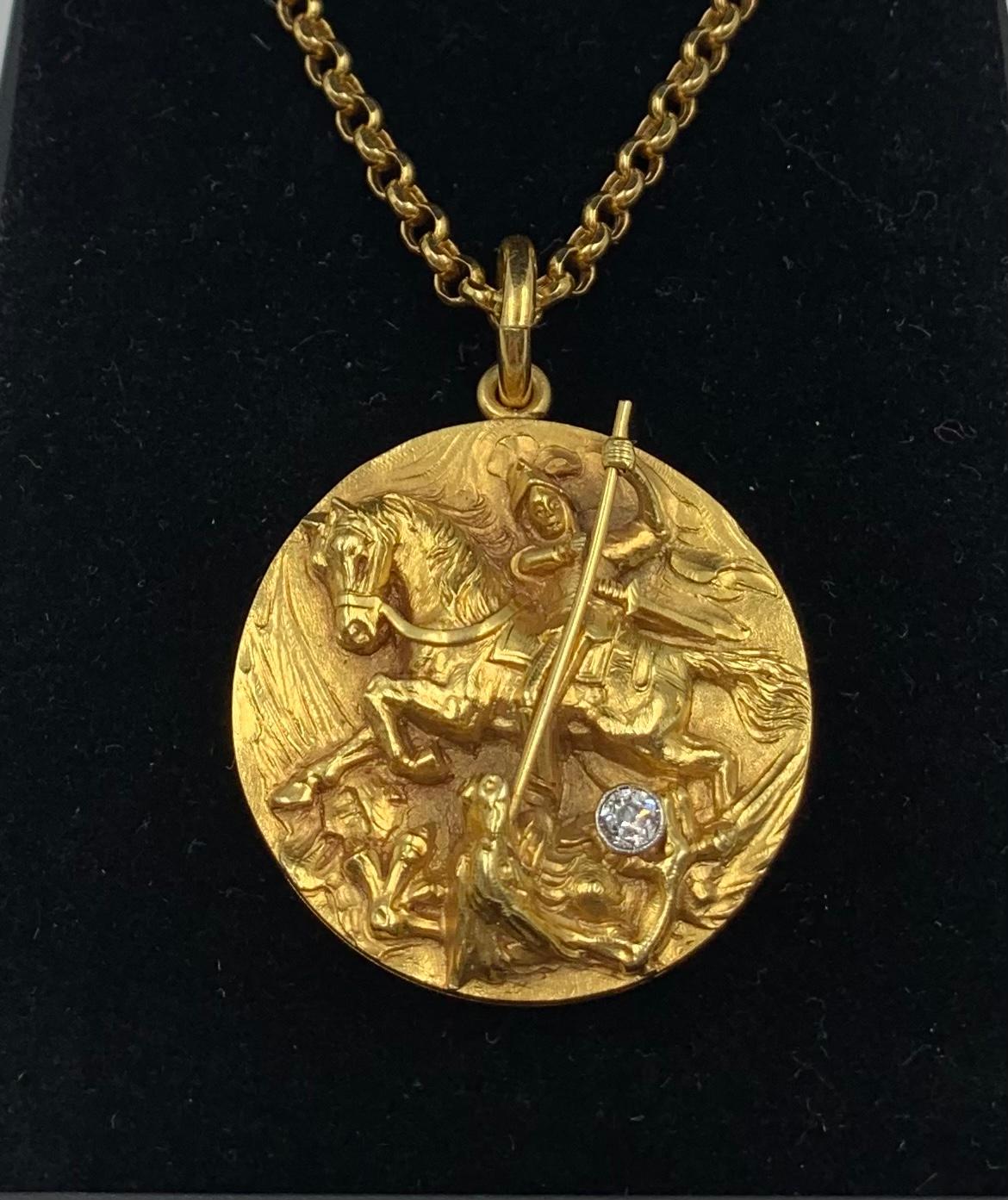 Spectacular 18K gold and diamond Saint George and the Dragon locket on a fabulous 33 inch long faceted 18K gold chain.
Finely hand chiseled in high relief with the dragon clasping a diamond in his claw. 
The interior and back in a lovely matte