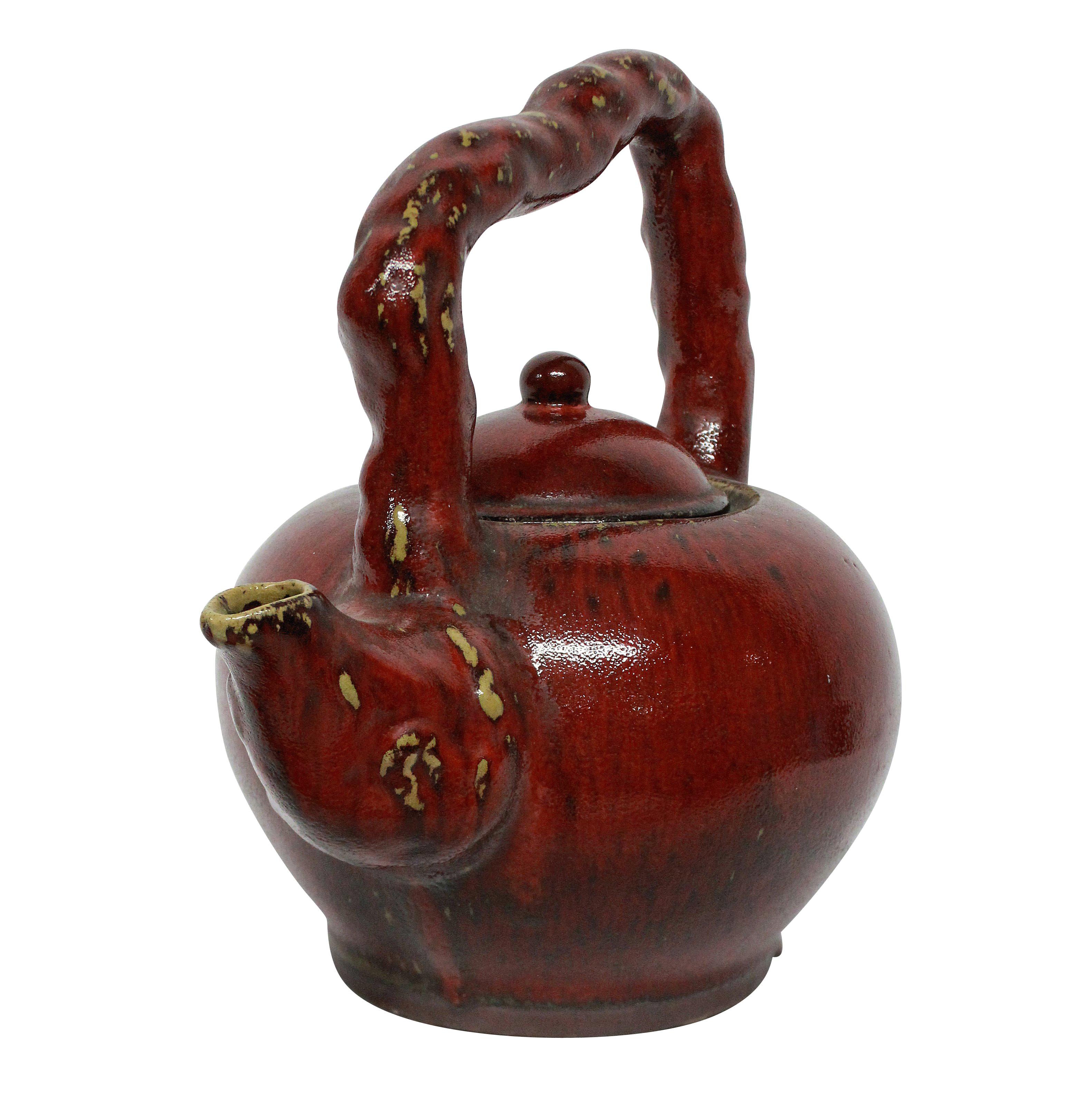 A large ornamental Japanese ceramic teapot with a sangue de boeuf glaze.