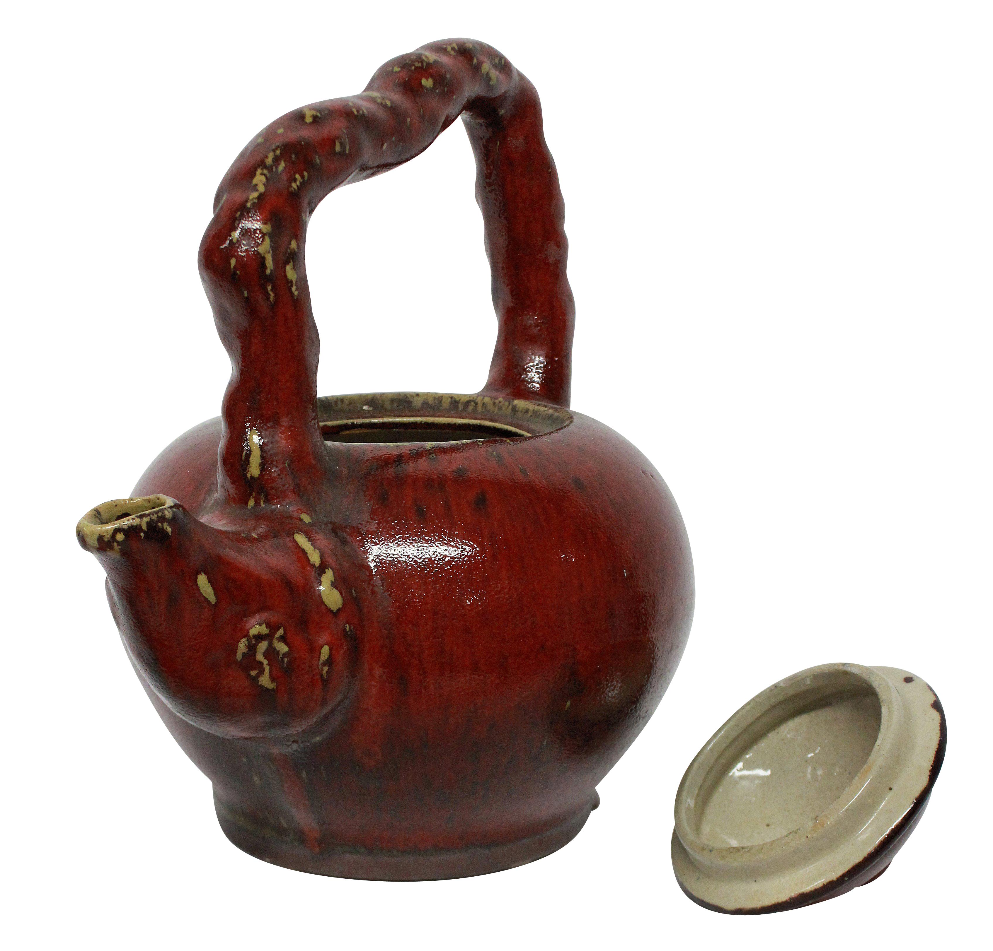A large ornamental Japanese ceramic teapot with a sangue de boeuf glaze.