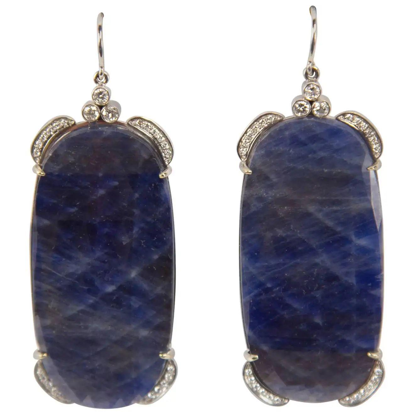 Sensational pair of Slice faceted D-end rectangular Blue Sapphire Dangle Earrings enhanced by round cut Diamonds; a total of 48 diamonds with a total weight of approx. .50 carat plus 6 diamonds with a total weight of approx. .30 carat; hand crafted