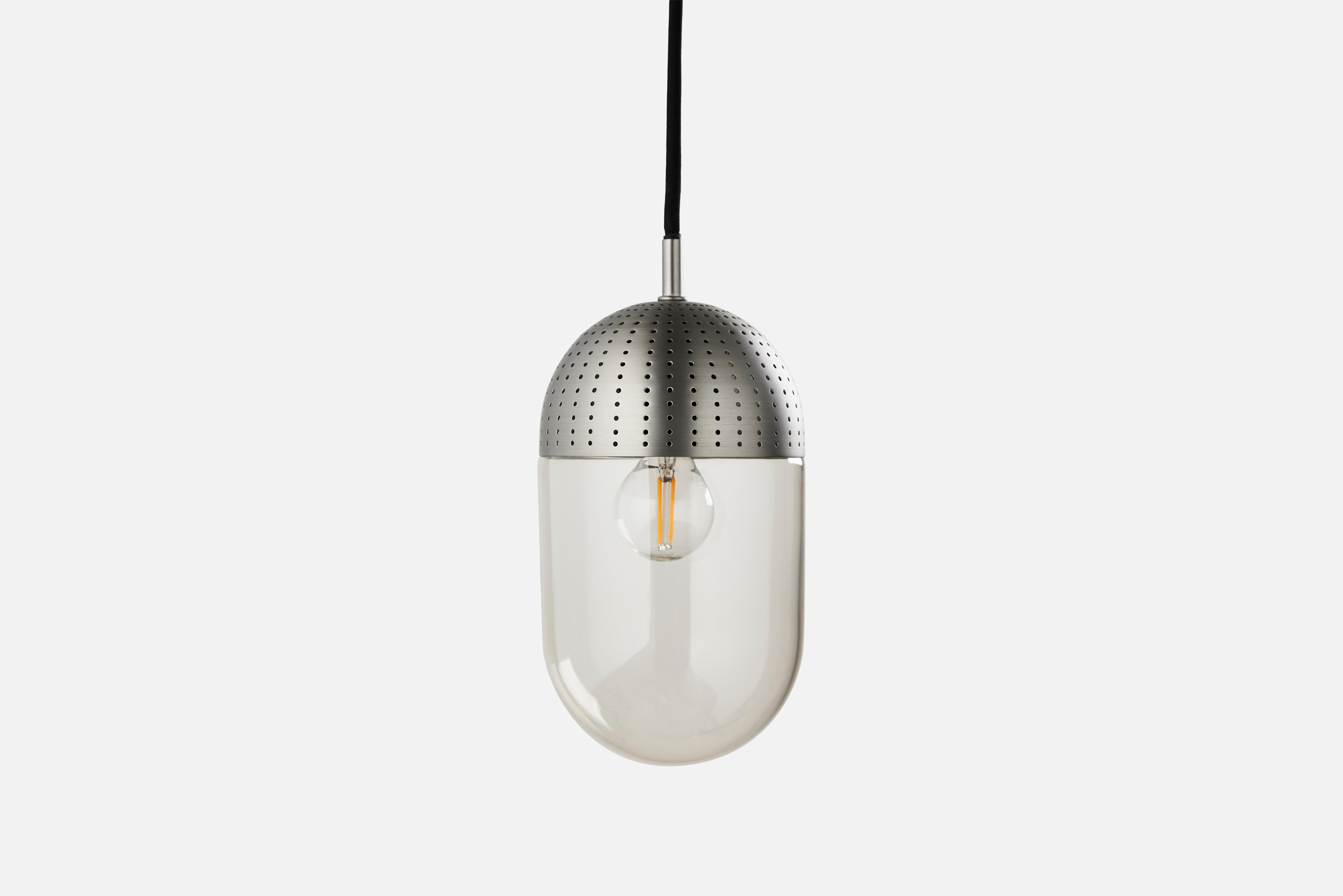Large satin dot pendant lamp by Rikke Frost
Materials: Metal, glass.
Dimensions: D 14 x H 21 cm
Available in black or satin and in 3 sizes: H13, H16.6, H21 cm.

Rikke Frost is a Danish graduate from the School of Architecture Aarhus. Since