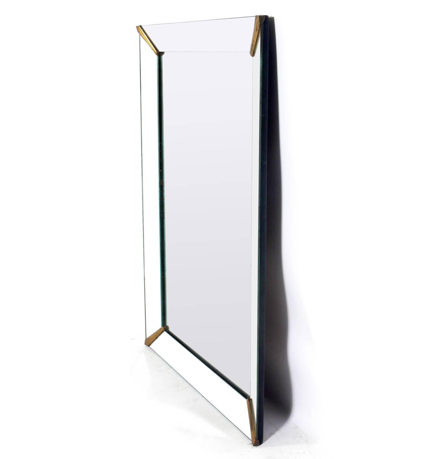 Elegant large-scale mirror with brass fittings, American, circa 1940s. Retains warm original patina to mirrors and brass fittings.