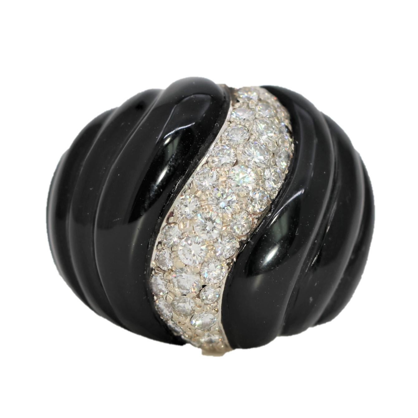 Created from 14k yellow gold, fluted black onyx and brilliant cut diamonds, this large scale ring has design area of 1 3/16 inch by 15/16 inch. 
Beautifully executed and very impactful, this ring which gives a sense of tranquil motion is set with 38