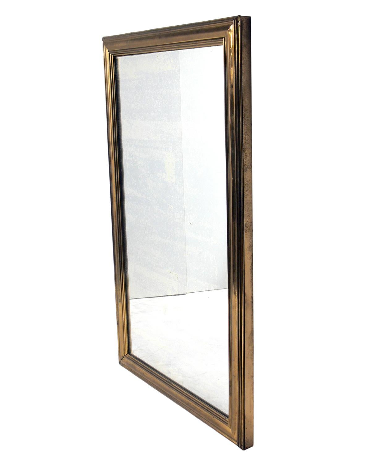 Large-scale 19th century brass mirror, circa 1890s. Retains wonderful original patina to the original mirrored glass and the brass frame.