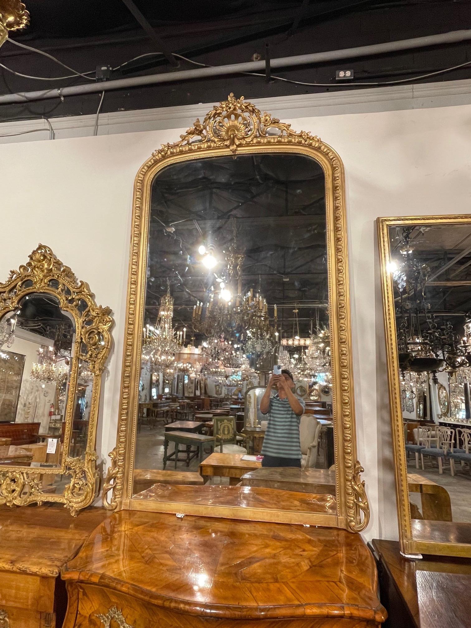 Exceptional large scale 19th century French Louis XVI style giltwood mirror. Beautiful carvings including an elaborate crown at the top with flowers. Gorgeous!!