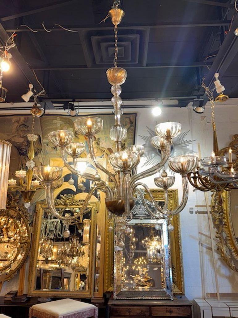 The Large Scale 2 Tier Murano Glass Chandelier in Fume Glass is a stunning lighting fixture designed in a chandelier style. It features two tiers of intricate Murano glass pieces in a fume glass finish, creating a luxurious and elegant appearance.