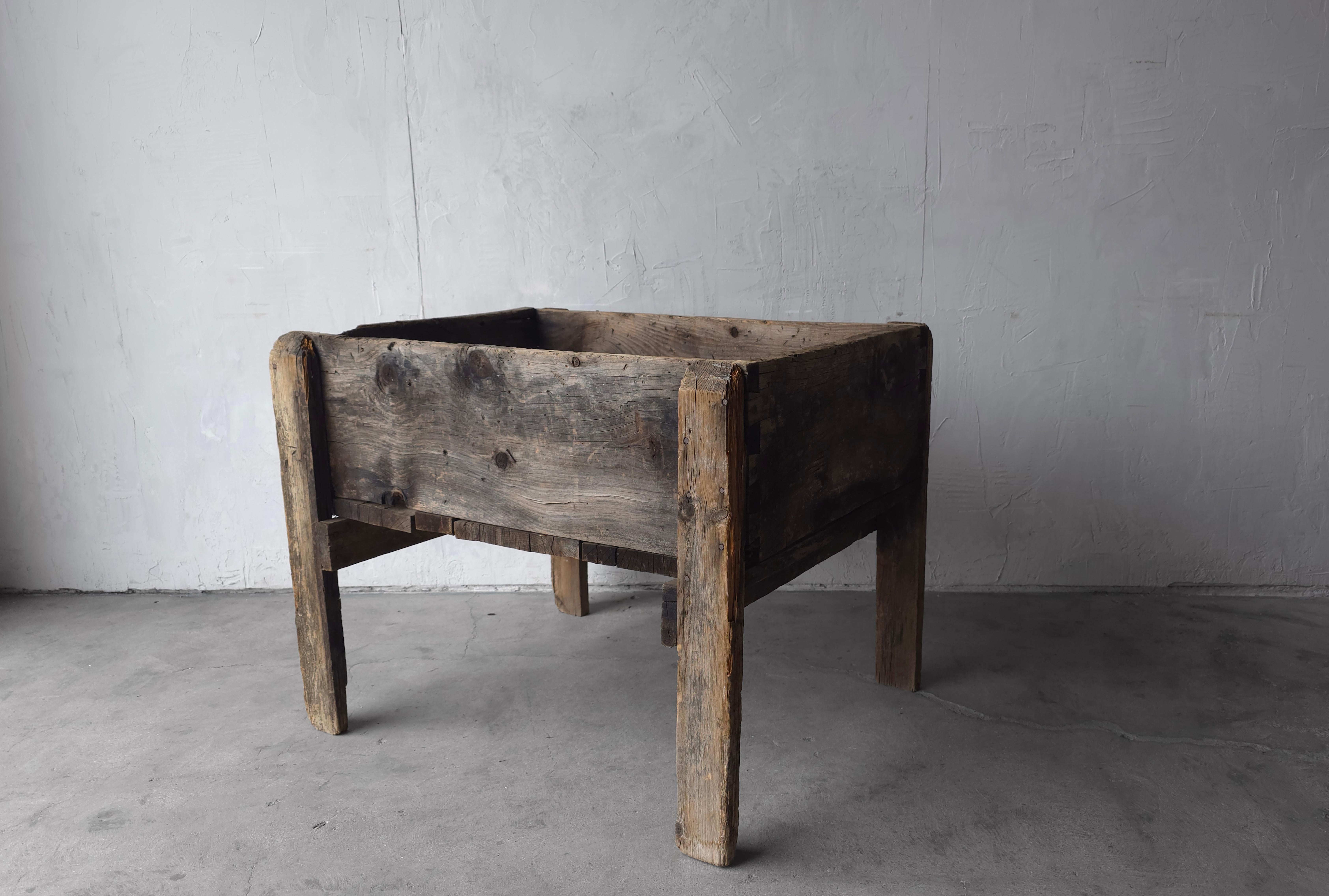 Pièce industrielle unique et ancienne.  Construit en bois massif qui a été magnifiquement et uniformément altéré par l'âge et l'utilisation.

J'adore l'aspect massif des détails de la queue d'aronde et la façon dont la verdure contraste avec le bois