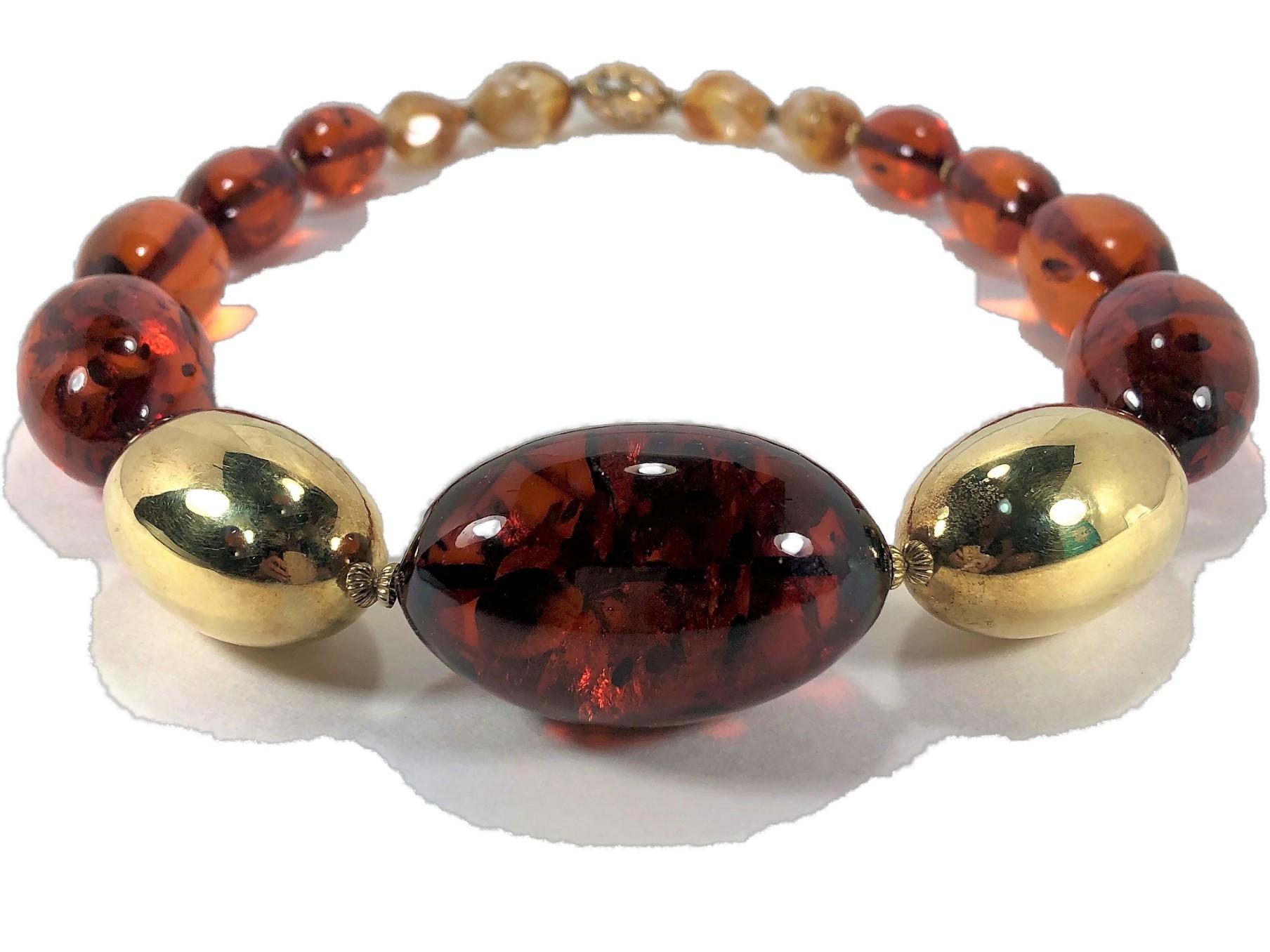 Made in Germany in the late 20th Century, this large 14K Yellow Gold and
Baltic Amber ovoid bead necklace makes a strong statement. The largest Amber
bead in the center measures 2 1/16 inches long by 1 1/4 inches wide. On either
side of the center