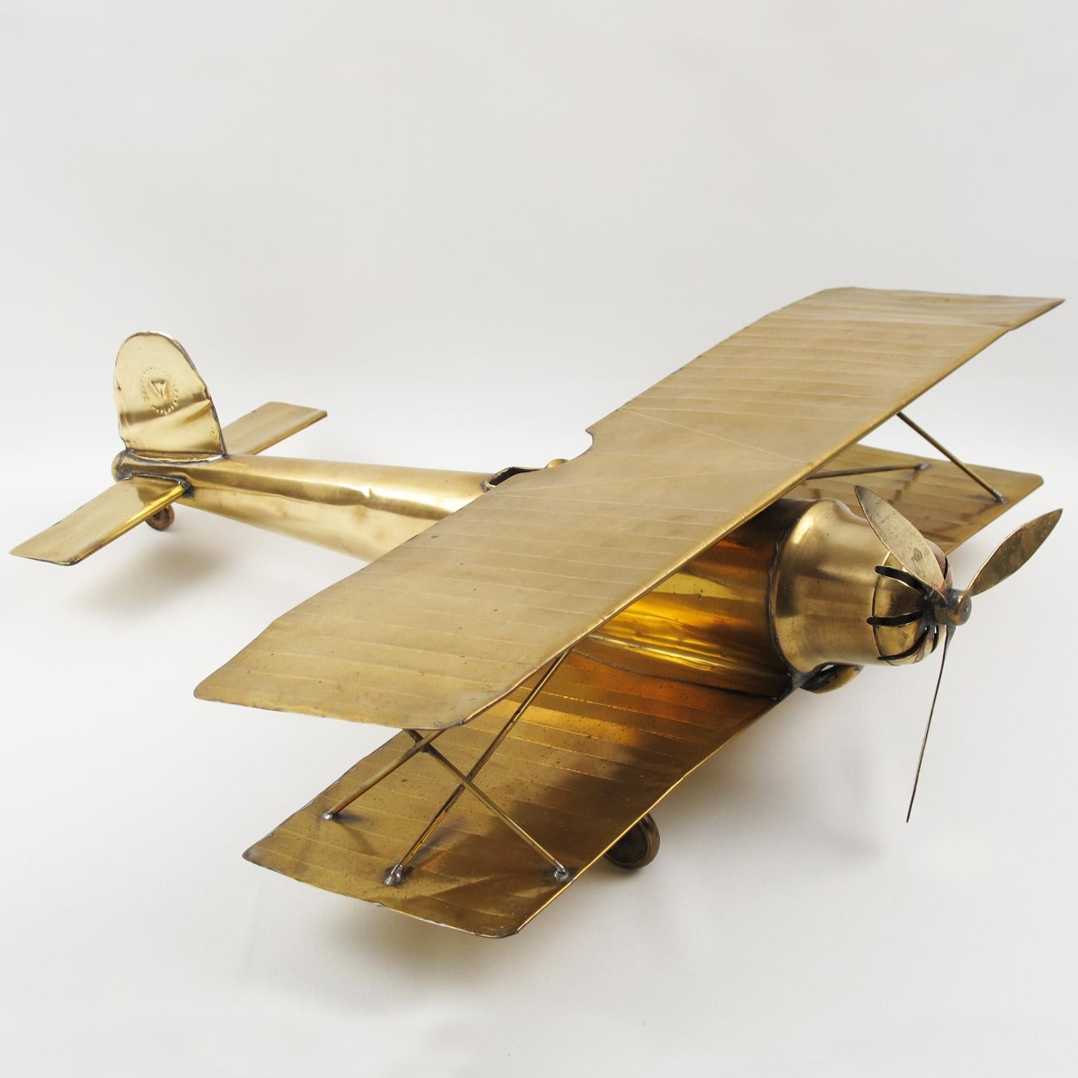 This stunning WWI-era biplane brass airplane was hand-crafted in the 1950s. It is a large-scale airplane model with intricate details and looks great hung from a ceiling or displayed on a desk. The single brass propeller is in rotating condition.