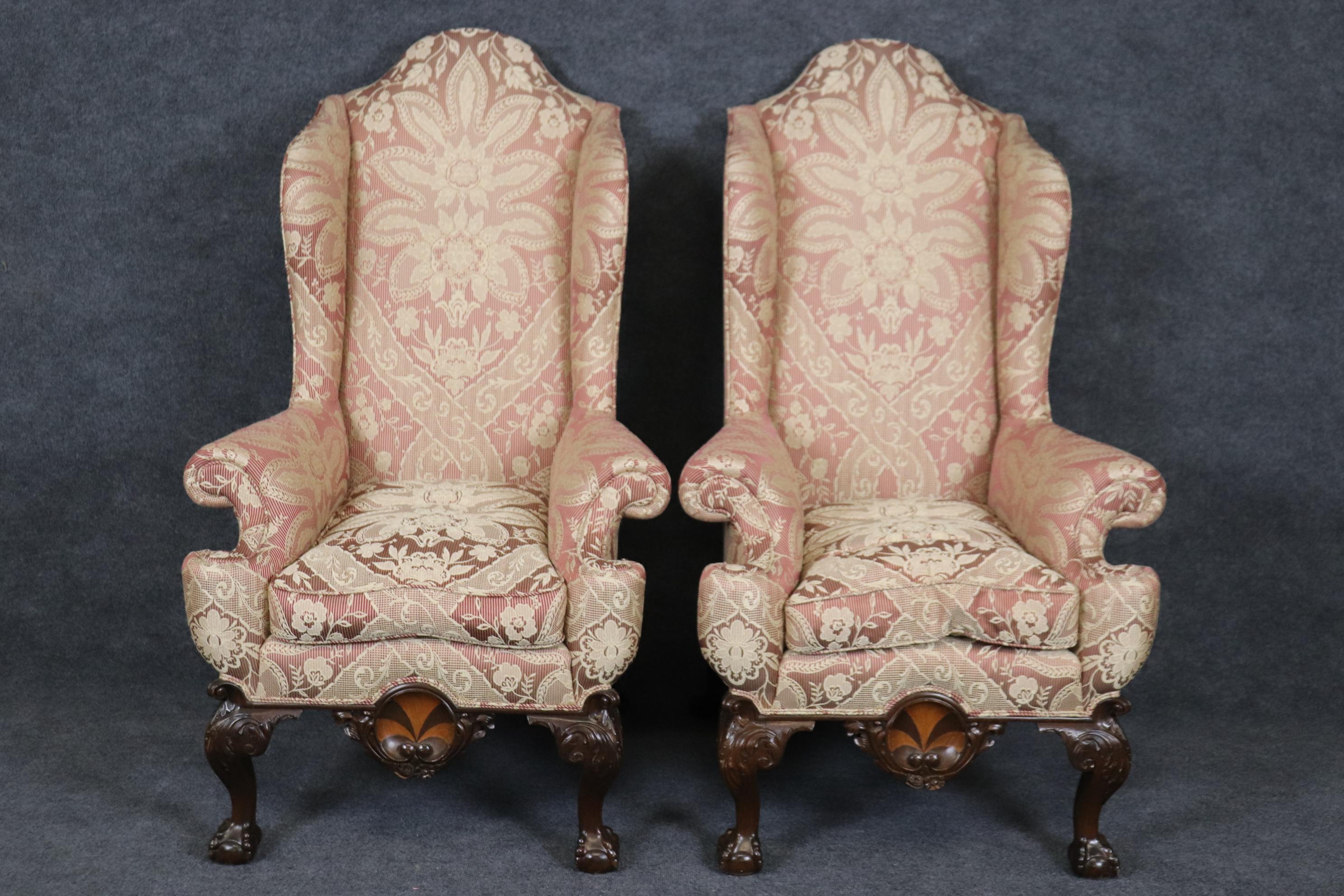 This is an impossing extremely large scale pair of Chippendale wingchairs. The chairs are in good antique condition and feature fresh upholstery that is used so it may not be perfect but seems very clean. They are extremely tall and comfortable.