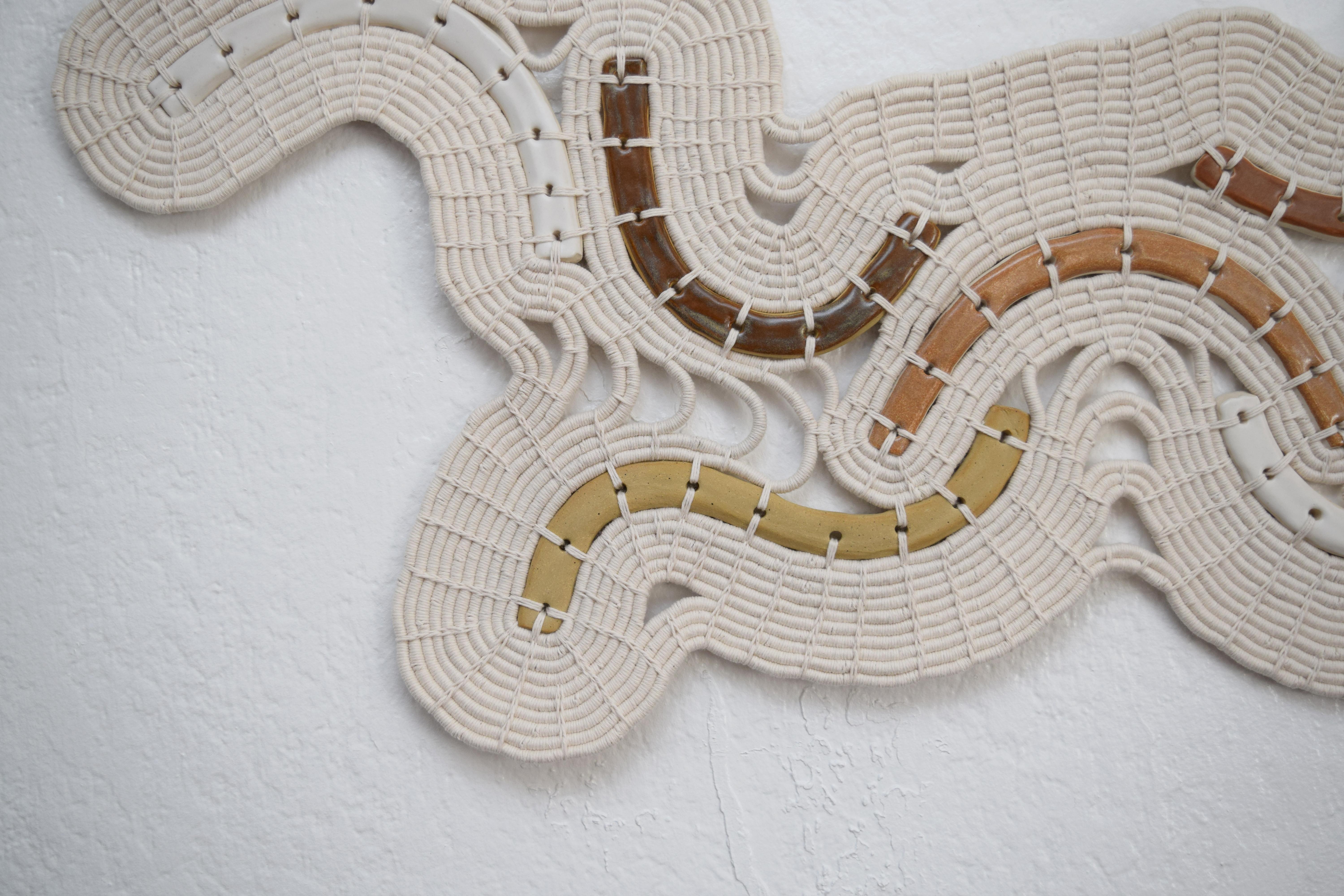 Wall sculpture #716 by Karen Gayle Tinney

One of a Kind Wall Sculpture in ceramic and cotton. Handmade ceramic shapes are finished using variety of neutral glazes. The ceramic pieces are linked together using a coiling technique in white cotton.