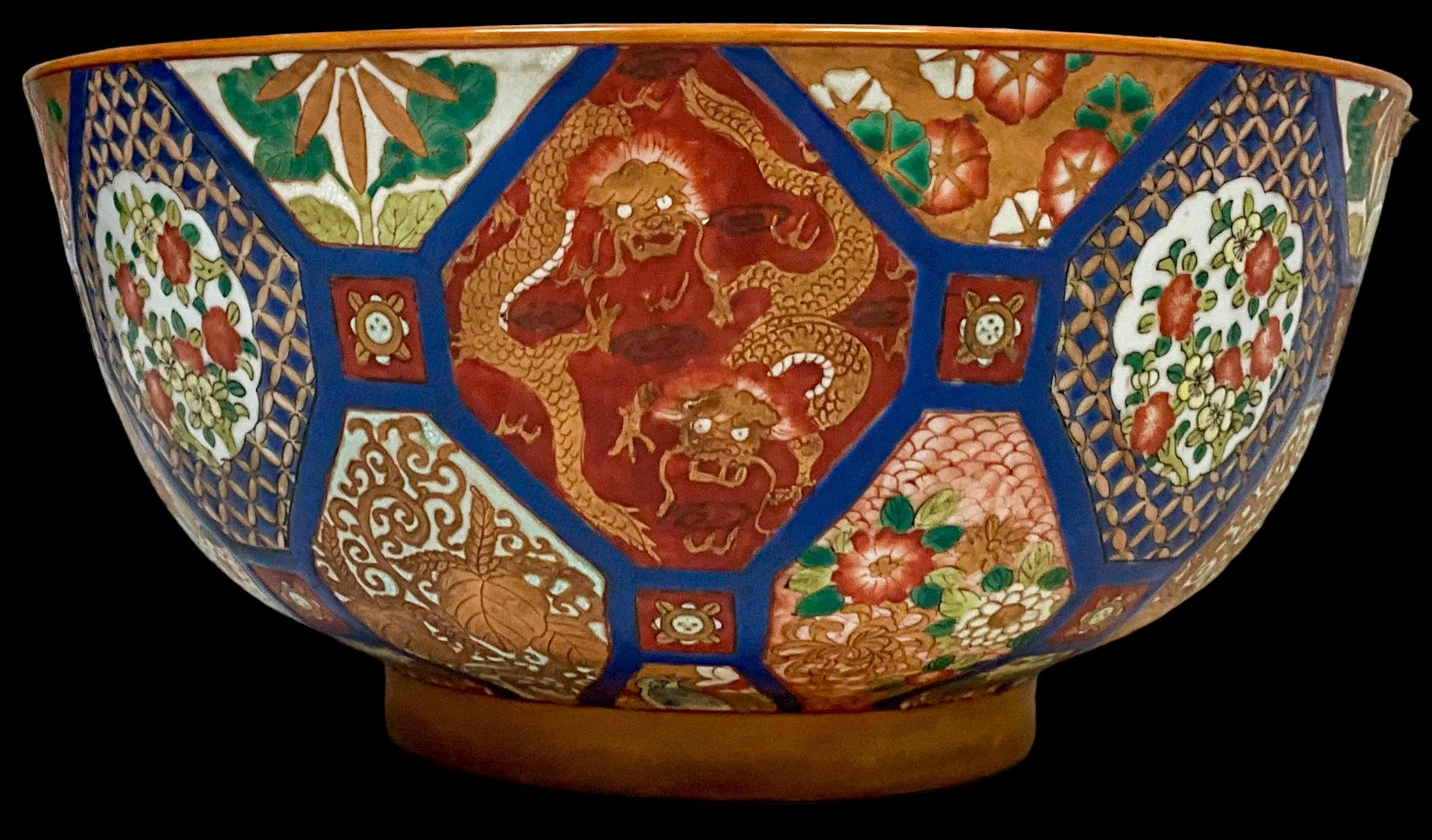 This is a late 20th century large scale Chinese Export style bowl. It has vivid blues and oranges with a dragon motif. It is marked and in very good condition.