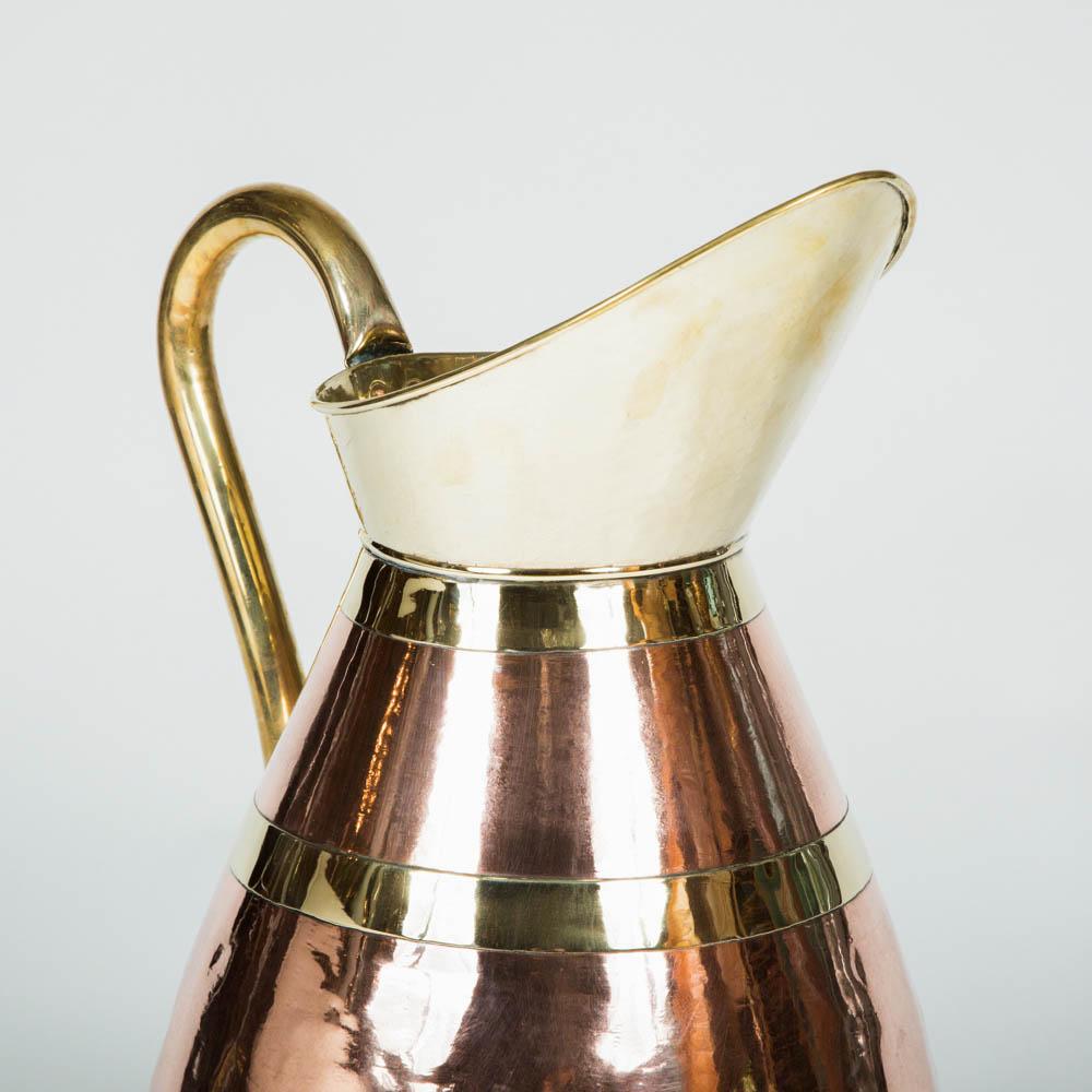 A large scale jug with copper and brass spout, handle and banding.

