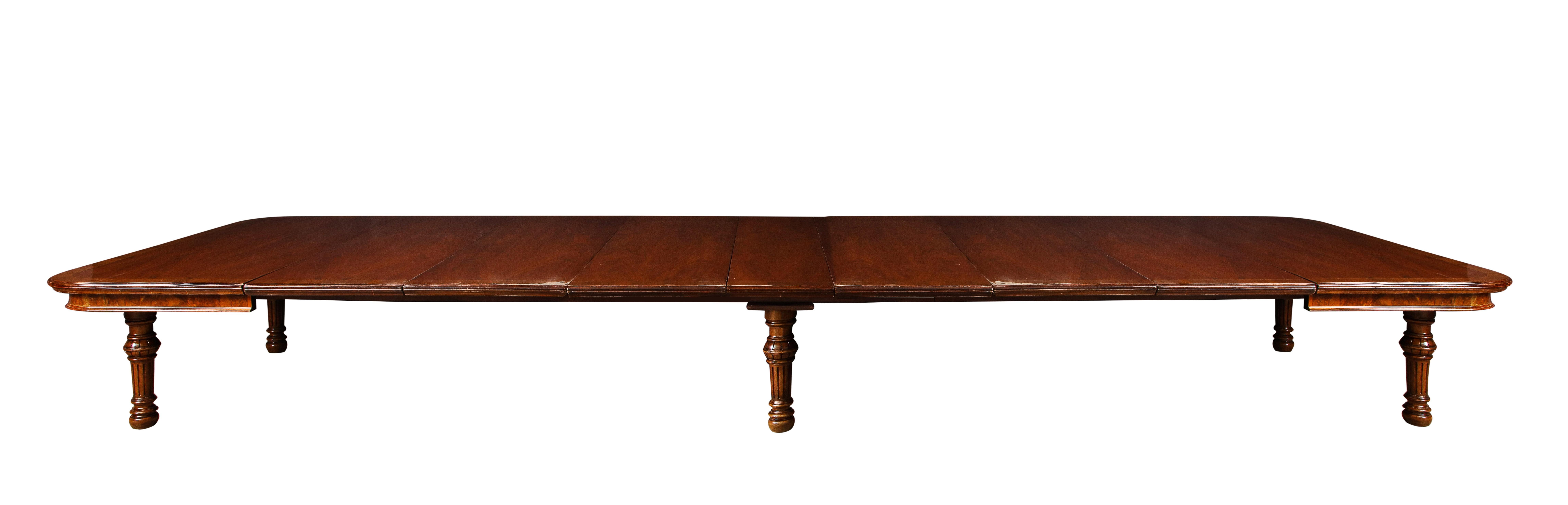 Monumental banded walnut dining table with banded edge on six turned and fluted legs. The table is 6' square when closed, and then opening to 20' with seven leaves. Stamped on each outside rail: GILLOWS #9046
Measures: 6' x 6' closed.