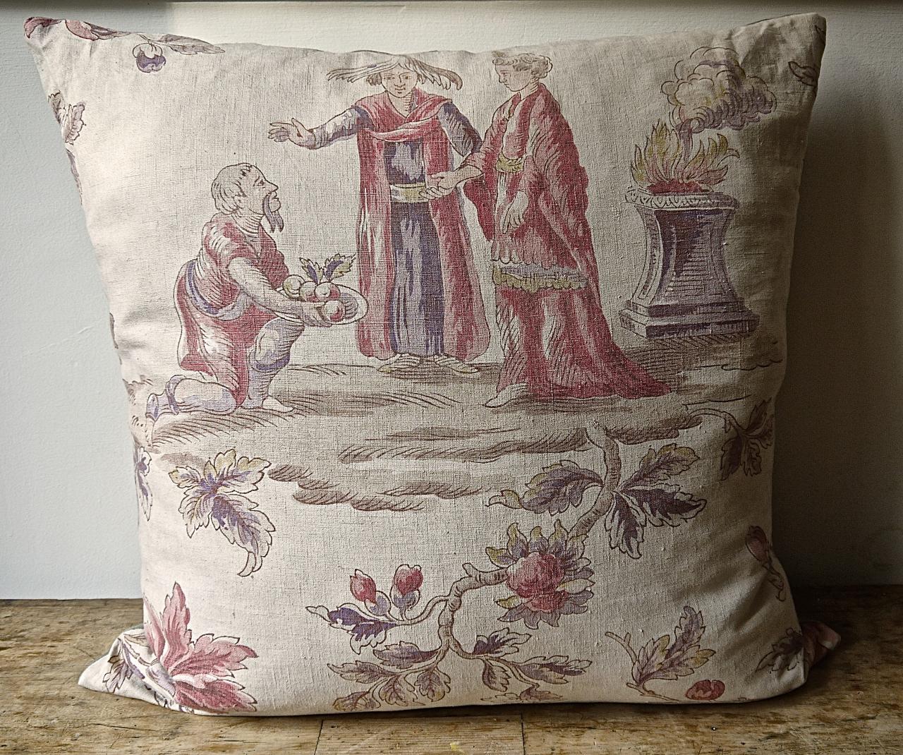 French early 20th century linen cushion printed with large scale historical figures and a meandering flowered branch in beautiful soft faded colors. Backed in a natural dye and hand dyed 19th century French linen and slip-stitched closed with a duck