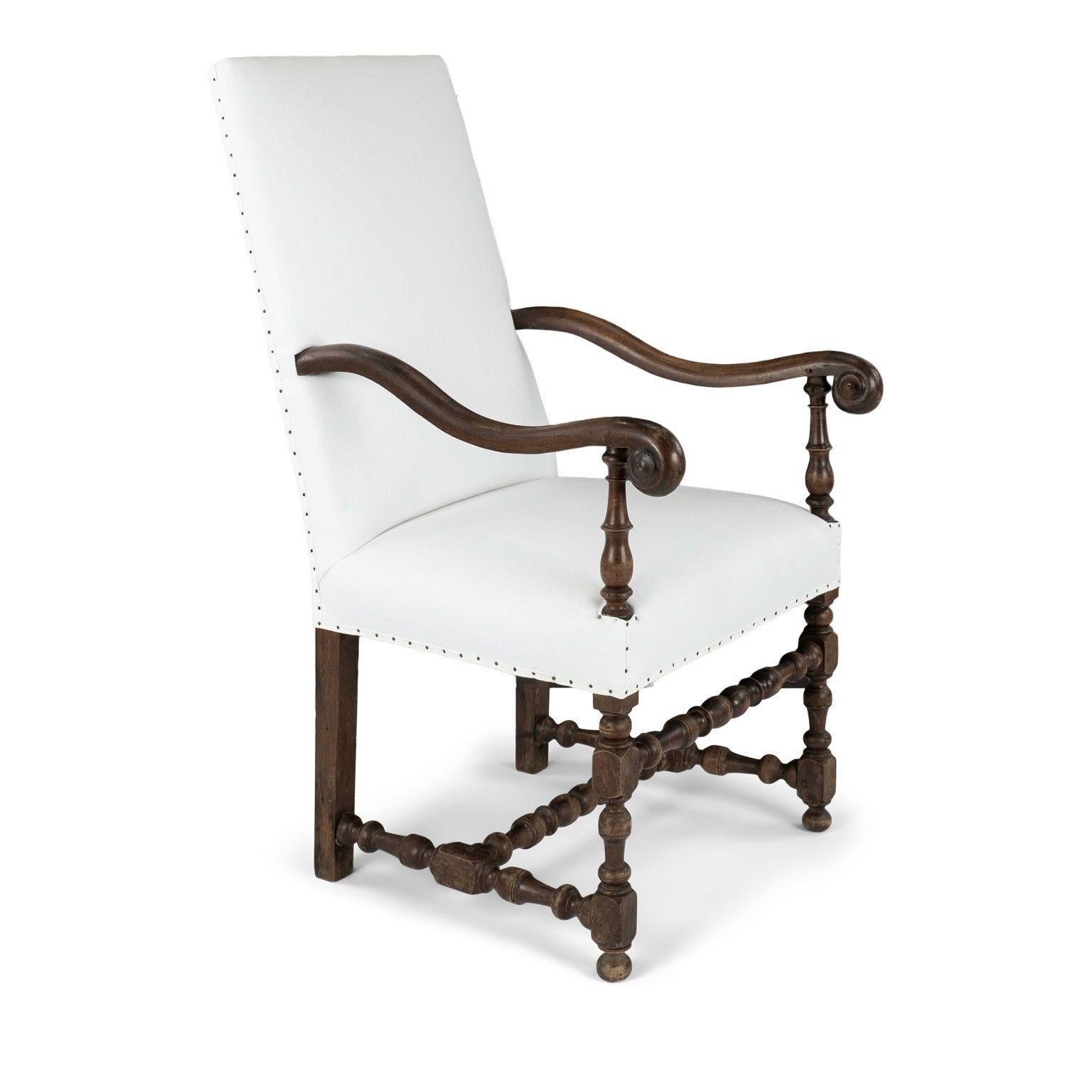 Large-scale French baroque armchair dating to early 18th century. Hand-carved in Louis XIII style in walnut with turned stretchers. Newly upholstered in white linen.

Note: Regional differences in humidity and climate during shipping may cause