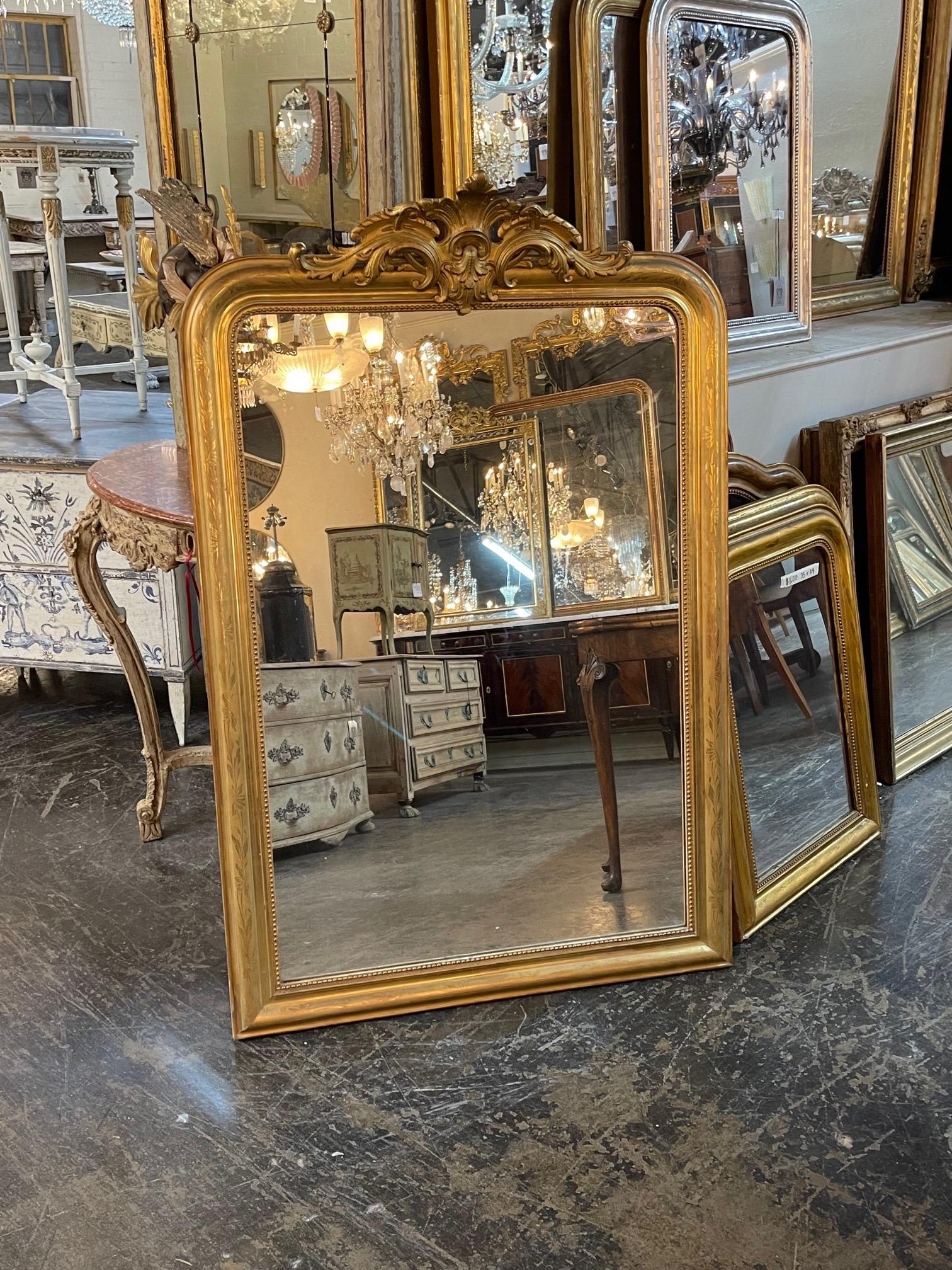 Very fine large scale French Louis Philippe mirror with a crest at the top. The piece also has a floral pattern along the sides and a beaded inner border. Lovely!