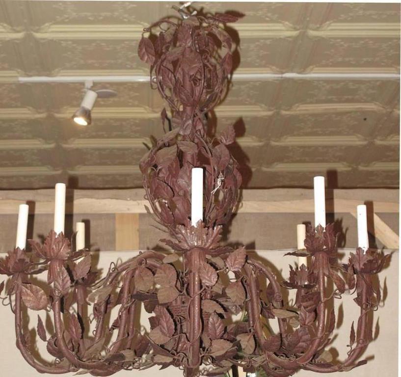 Large French tole chandelier mounted with vinework. The chandelier of a dark burgundy color. The chandelier, circa 1920s-1930s.
 