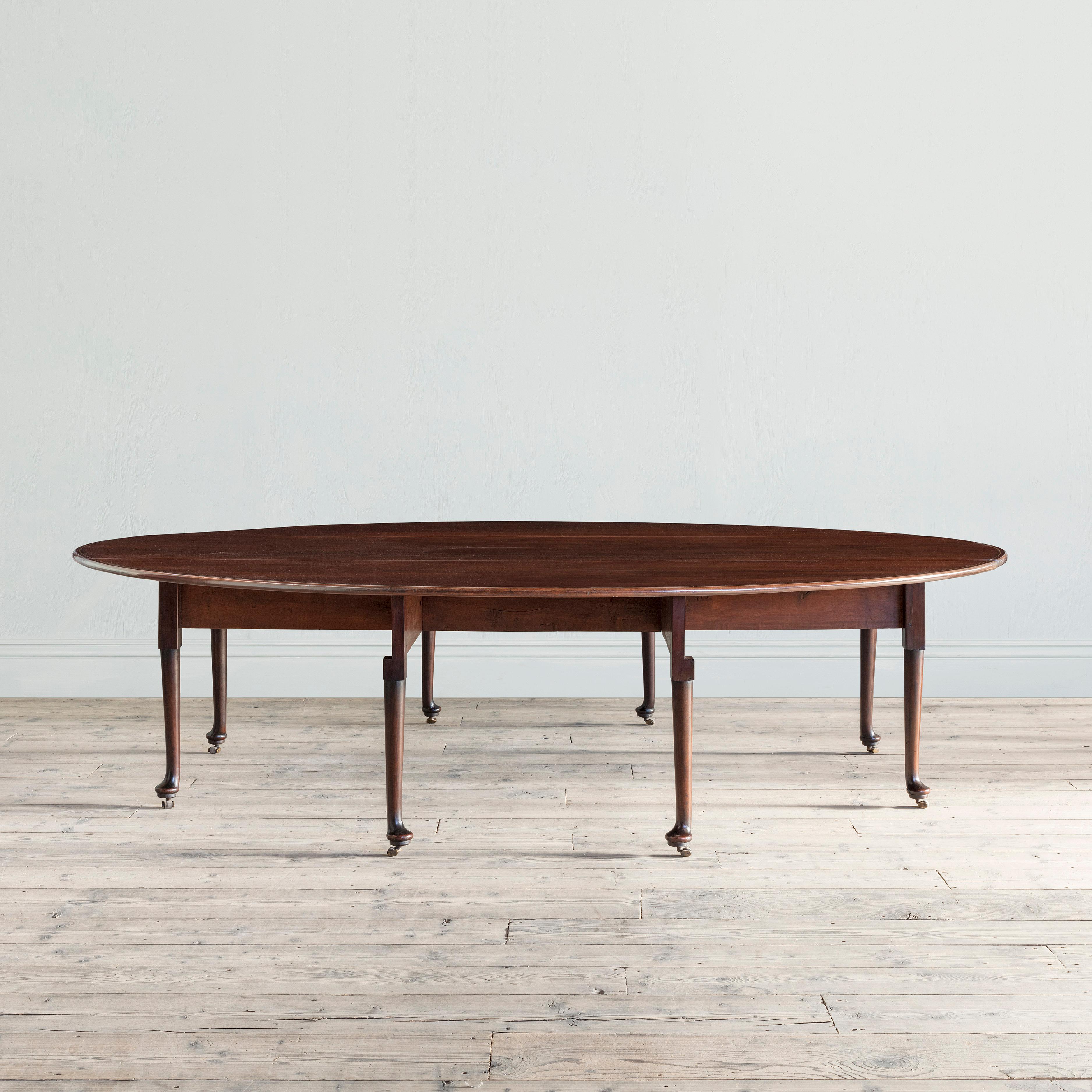 An extraordinary scale George II mahogany and brass strung drop-leaf table
The oval top supported on turned and tapering legs and pad feet, the eight legs terminating in brass and leather casters.

Unusual for its magnificent scale and