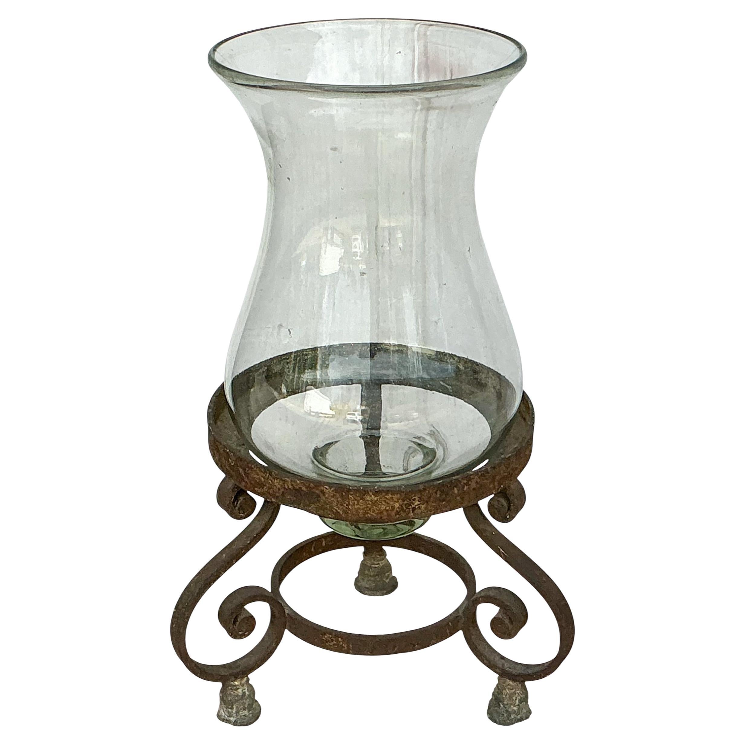 This is a hand forged iron and blown glass candle holder. It is an artist rendering from antique salvaged pieces.  It is in very good condition has a nice large scale. 