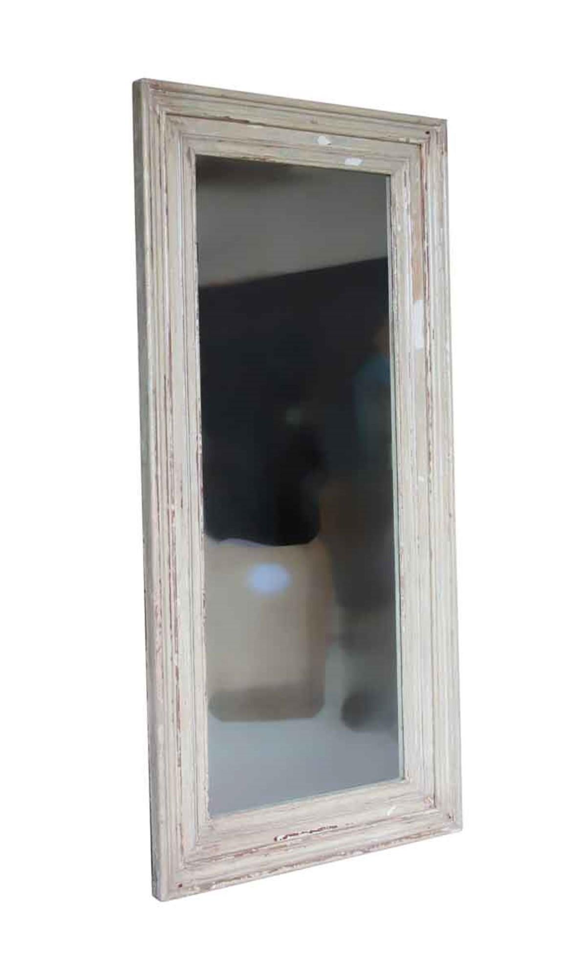 Large scale mirror handmade from reclaimed 1890s wood door molding with original distressed tan paint. The molding comes from turn of the century New York City brownstones. This can be seen at our 302 Bowery location in NoHo in Manhattan.