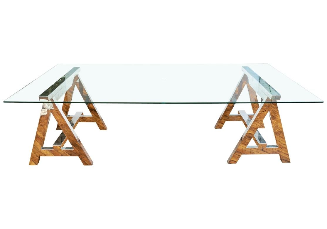 Modern glass top Desk or dining Table. With two heavy Saw Horse Chrome supports with flat raised stretchers on each end. Topped with glass. The glass has a central  hole for wires if used as a desk. 

 Dimensions: Length 95