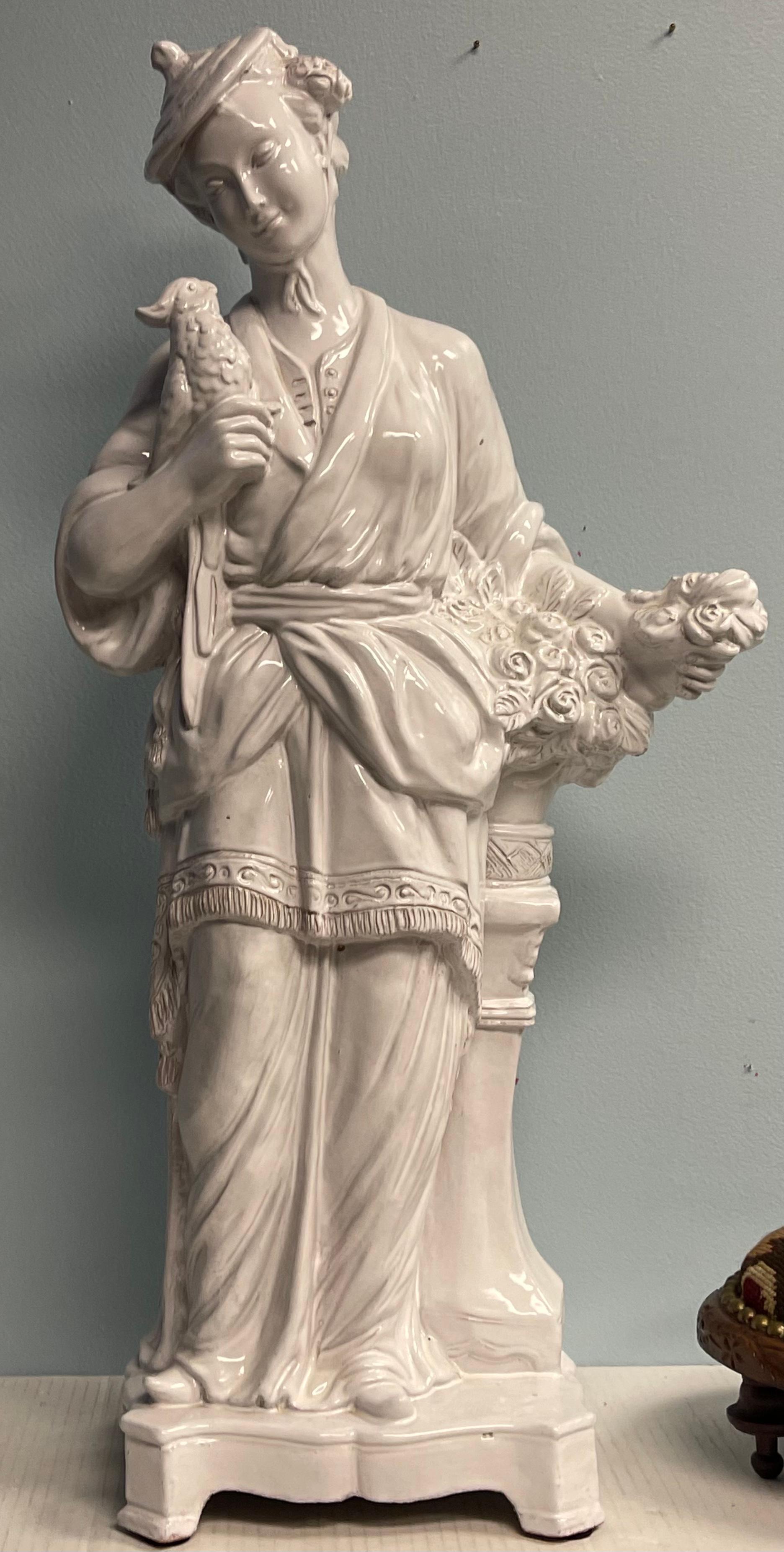 Il s'agit d'une belle figurine féminine en terre cuite glacée italienne à grande échelle. Elle tient un oiseau. La glaçure blanche de la majolique lui donne un aspect de Blanc de Chine.