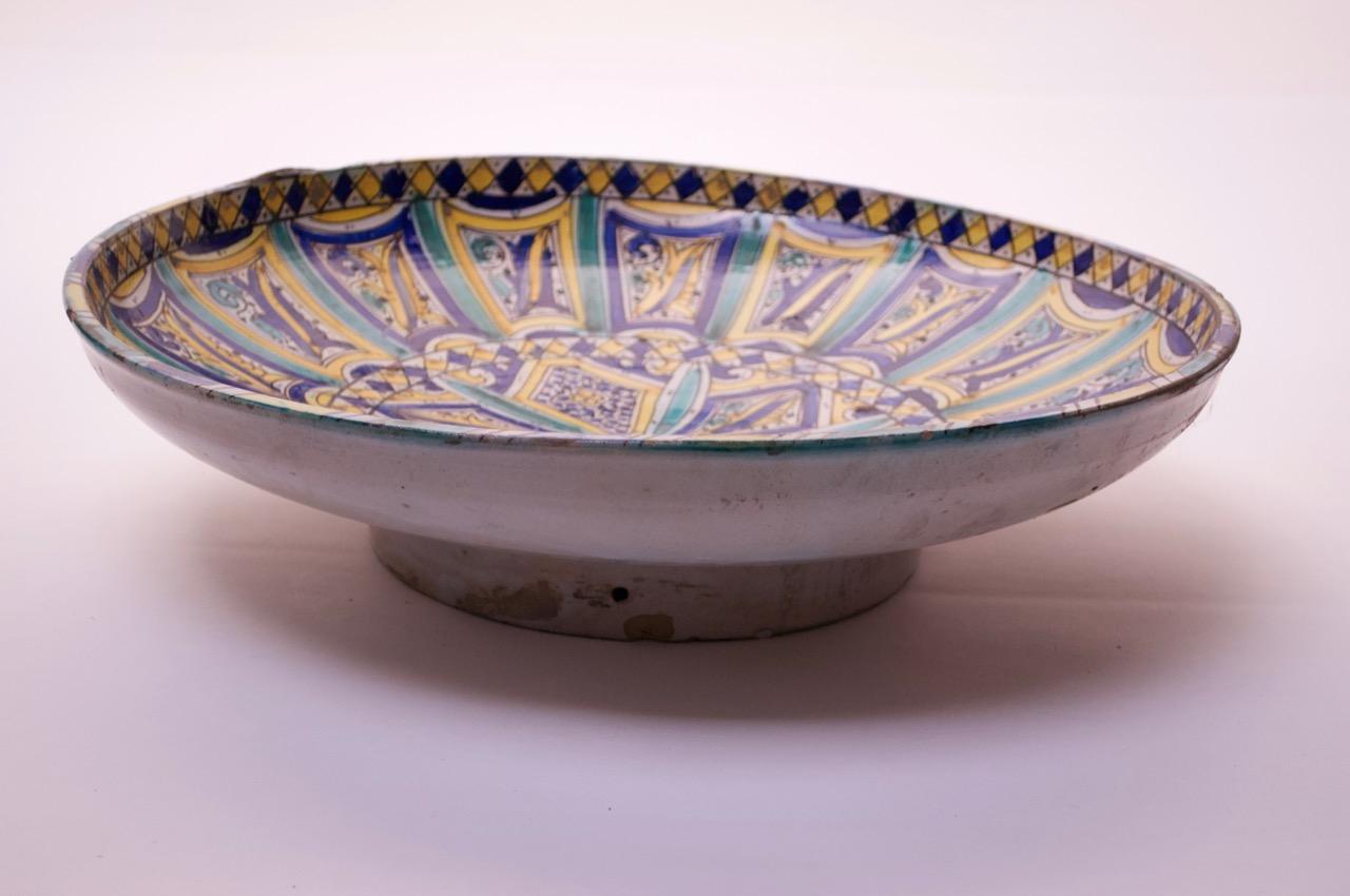 Large-scale terracotta charger (circa 1940s, Italy) with bright blue, teal, and yellow geometric patterns with ornamental floral decoration in the center. There is some edge loss, but what appears to be more significant losses are original to the
