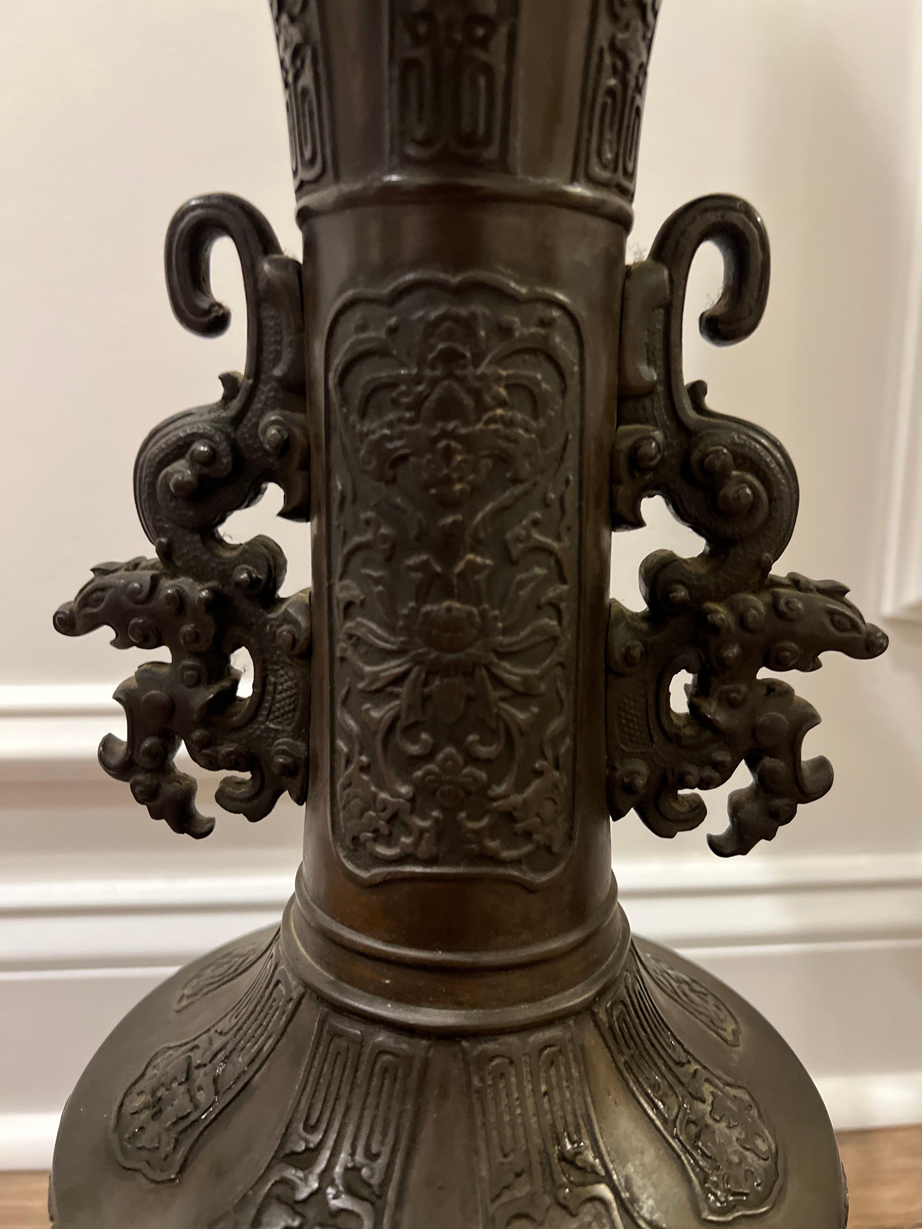 Japanese, circa 1900.

A pair of antique Japanese bronze table lamps. The lamps feature a detailed body showcasing applied lotus blossom and bird motifs to center, traditional Japanese motifs throughout and good quality guardian handles to