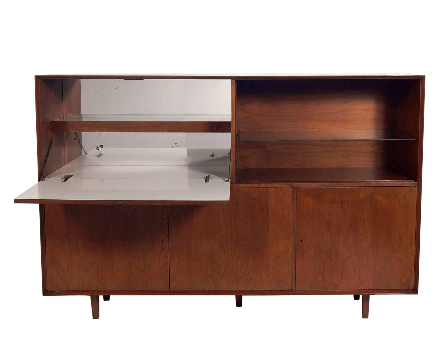 Large-scale midcentury bar cabinet or credenza, probably American, circa 1960s. Beautiful graining to the walnut. This piece is a versatile size and can be used as a bar cabinet, credenza, desk, secretary, or media cabinet in a living area, or as a