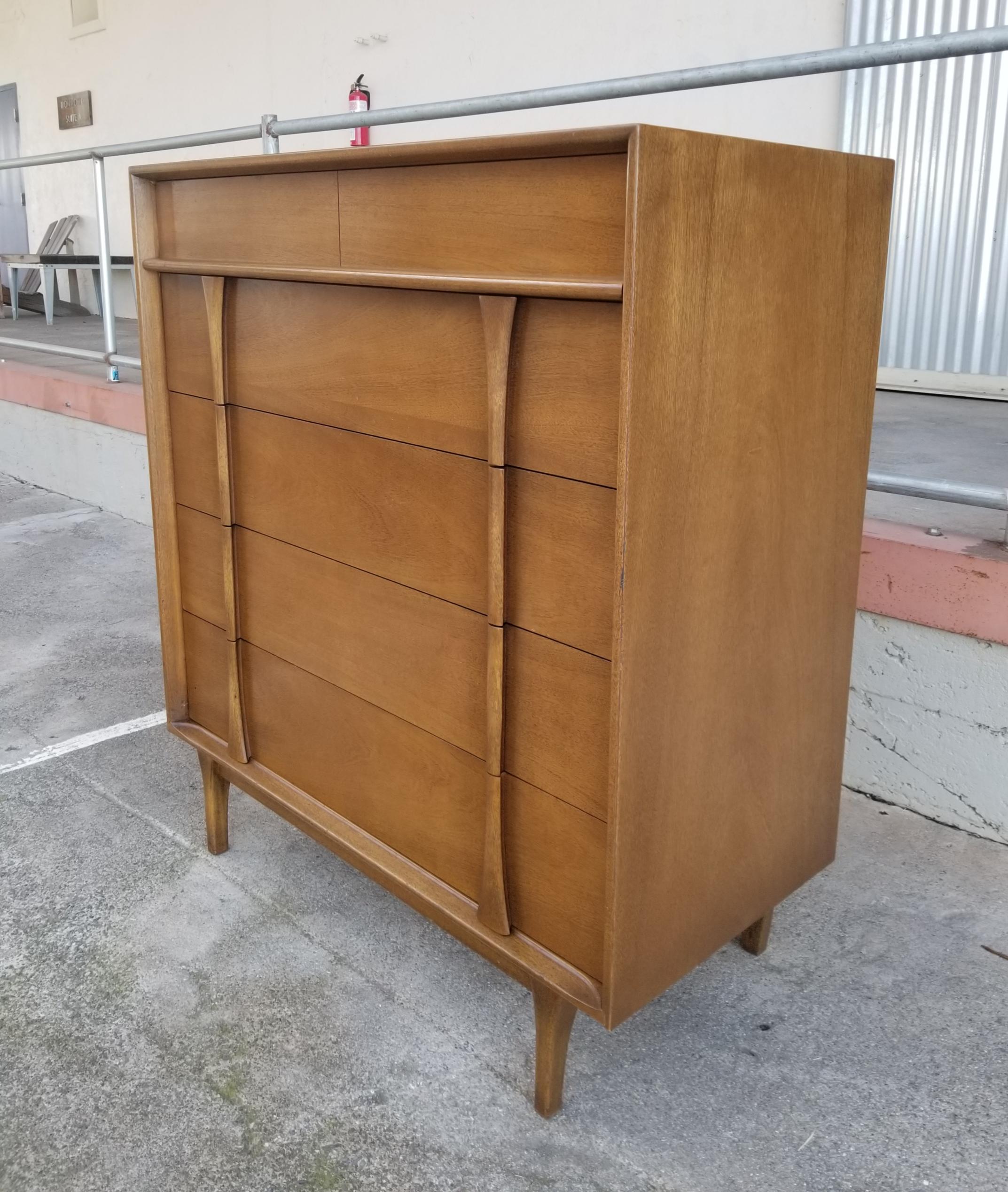 Fine craftsmanship and materials in this over-sized Mid-Century Modern highboy dresser by Red Lion Table Company, circa 1950s. Hourglass sculptural design. Solid oak dovetailed secondary woods. Center glides with wood dust panel between each drawer.