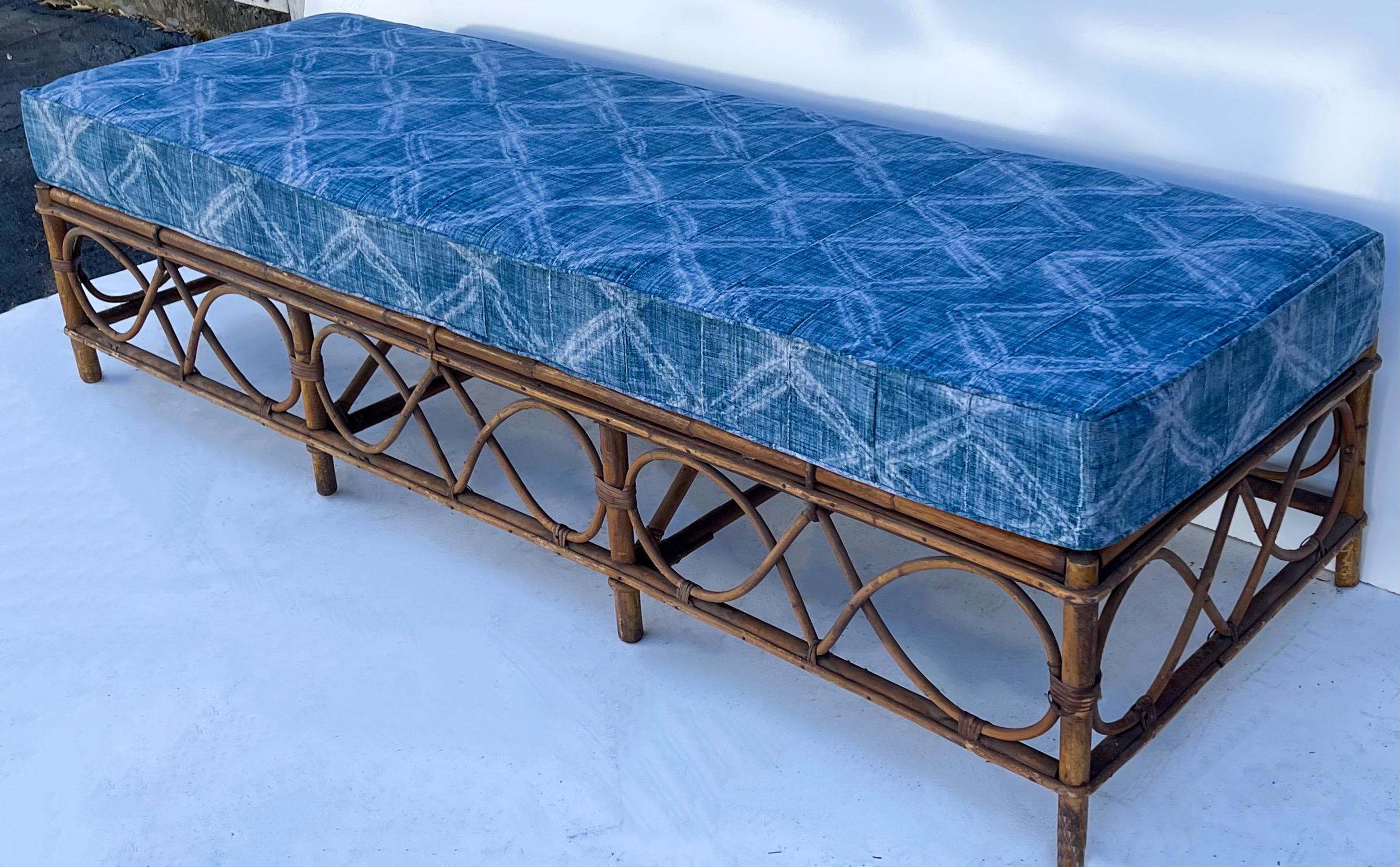 This is a large scale Mid-Century Modern rattan bench with a custom navy batik cotton fabric. The base is a rustic natural woven rattan. A versatile family friendly piece!