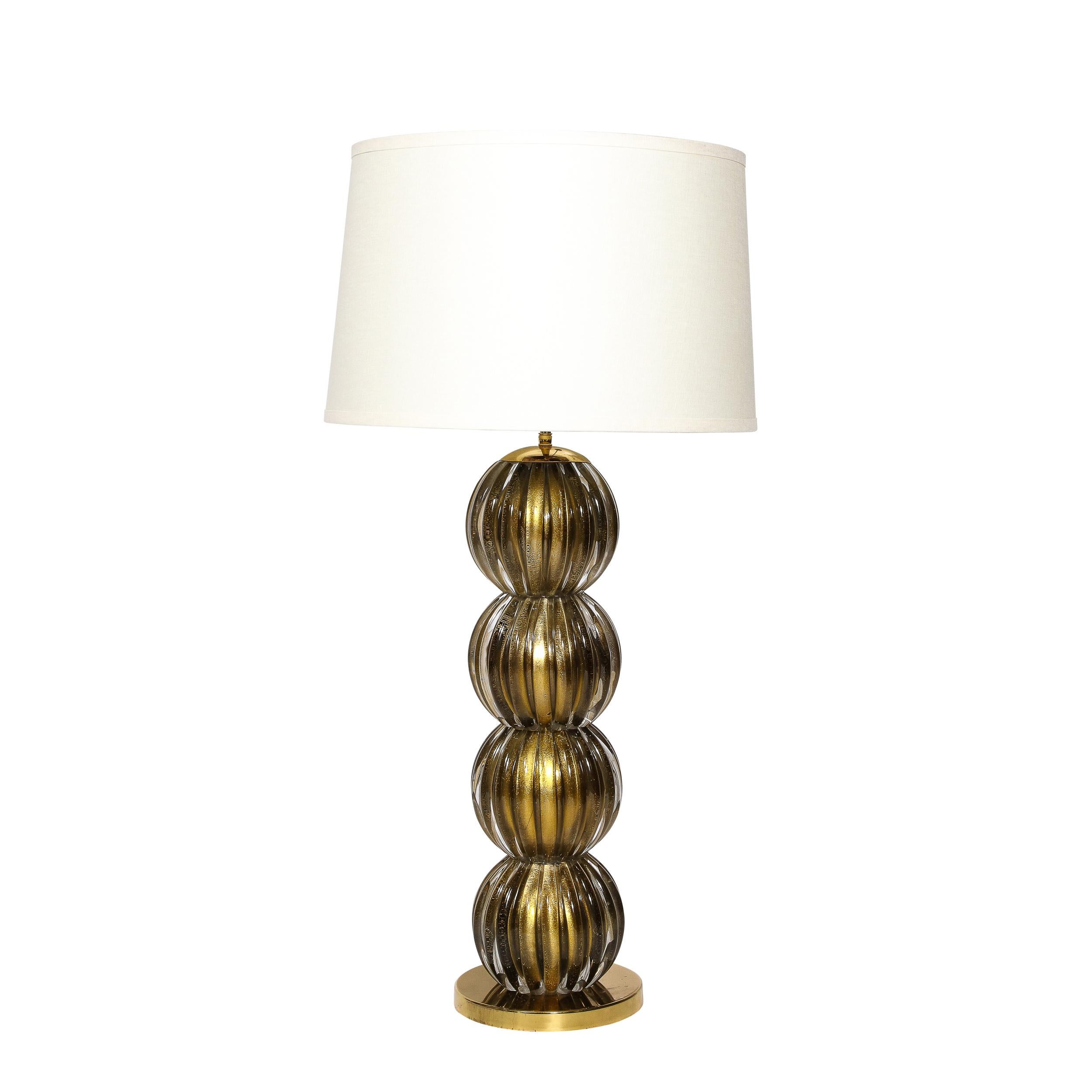 This impressive pair of large scale table lamps were realized in Murano, Italy- the island off the coast of Venice renowned for centuries for its superlative glass production- during the latter half of the 20th century. They feature circular brass