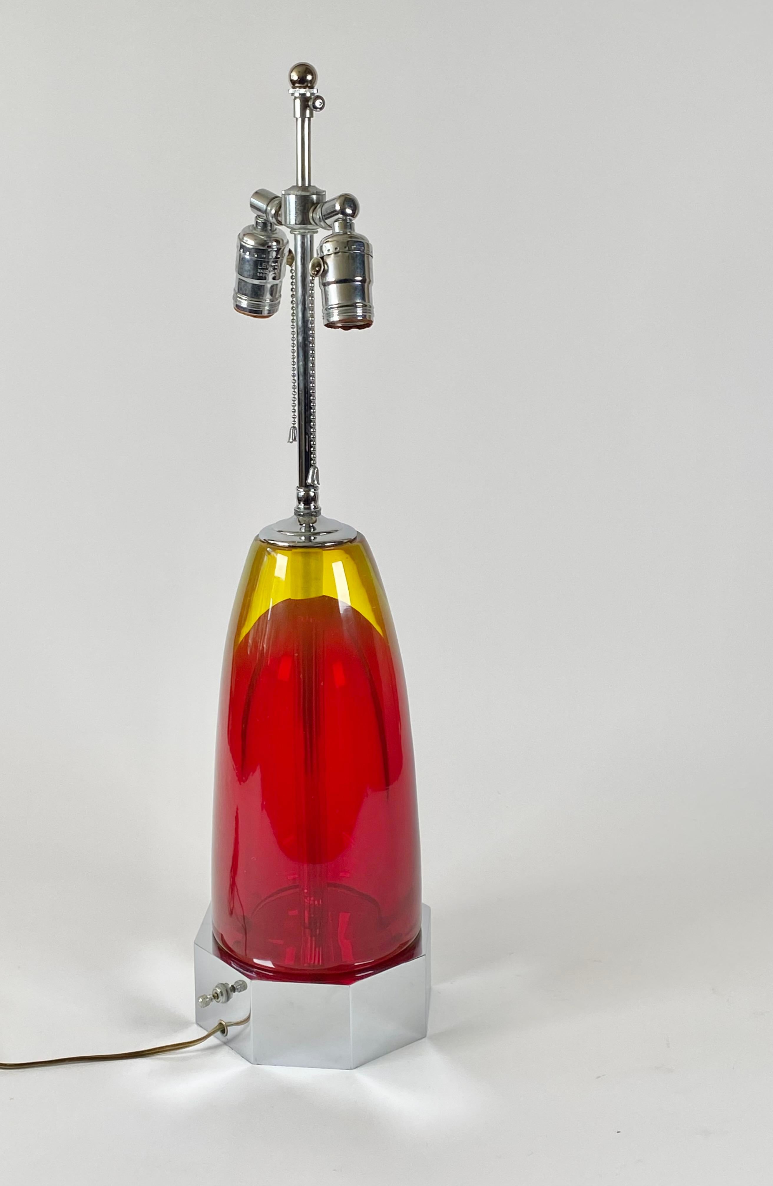 Lampe en verre de Murano fabriquée à la main vers les années 1950 ou le début des années 1960, corps en verre épais d'une couleur rouge tendre contrastant avec le vert doré, avec le matériel chromé d'origine de haute qualité, avec deux prises à