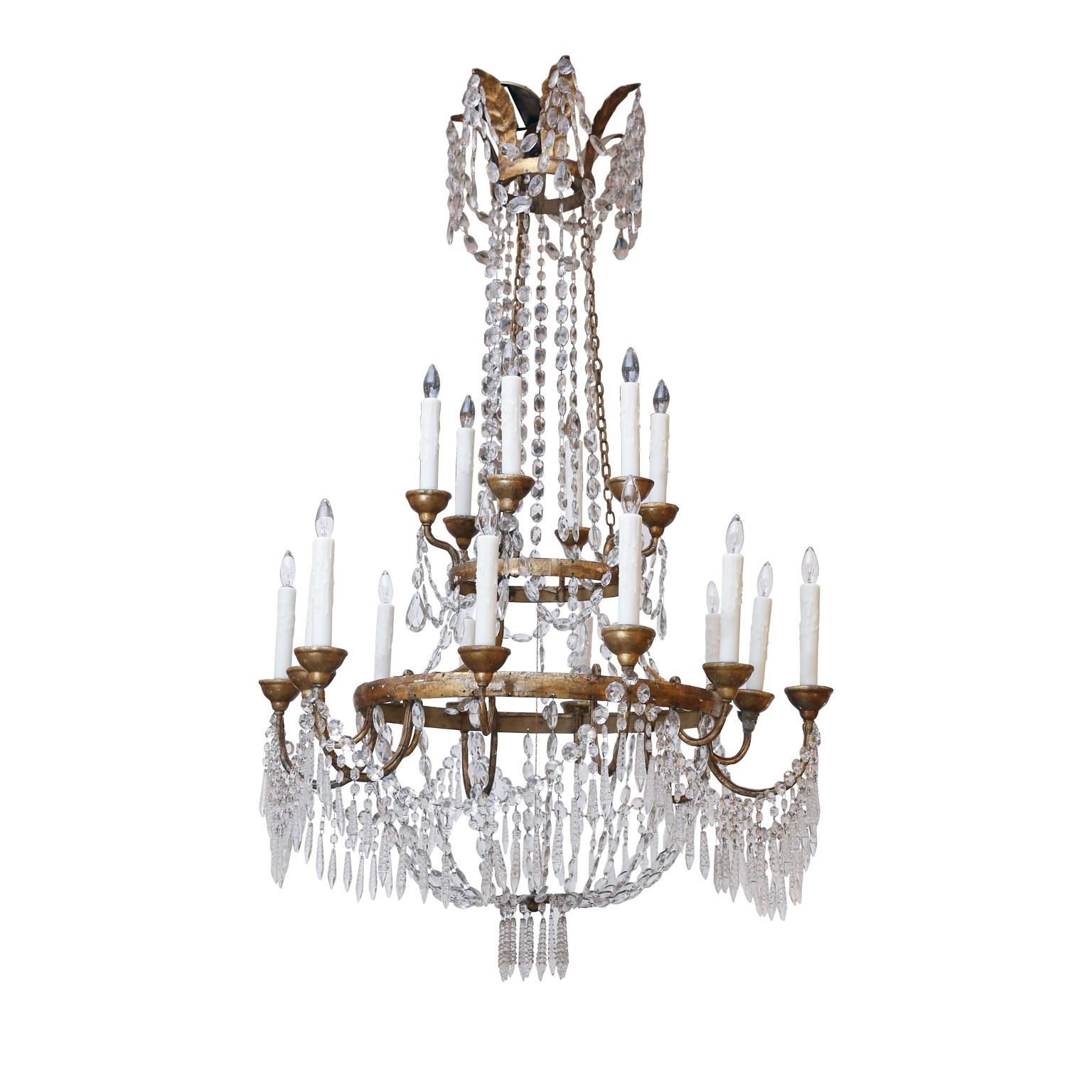 Large scale neoclassical chandelier from Lucca, Italy. Two gilt-iron ring tiers supporting eighteen arms (twelve lower and six upper). Decorated in original, or early, cut crystal prisms and pressed glass pendants. Newly wired using all UL listed