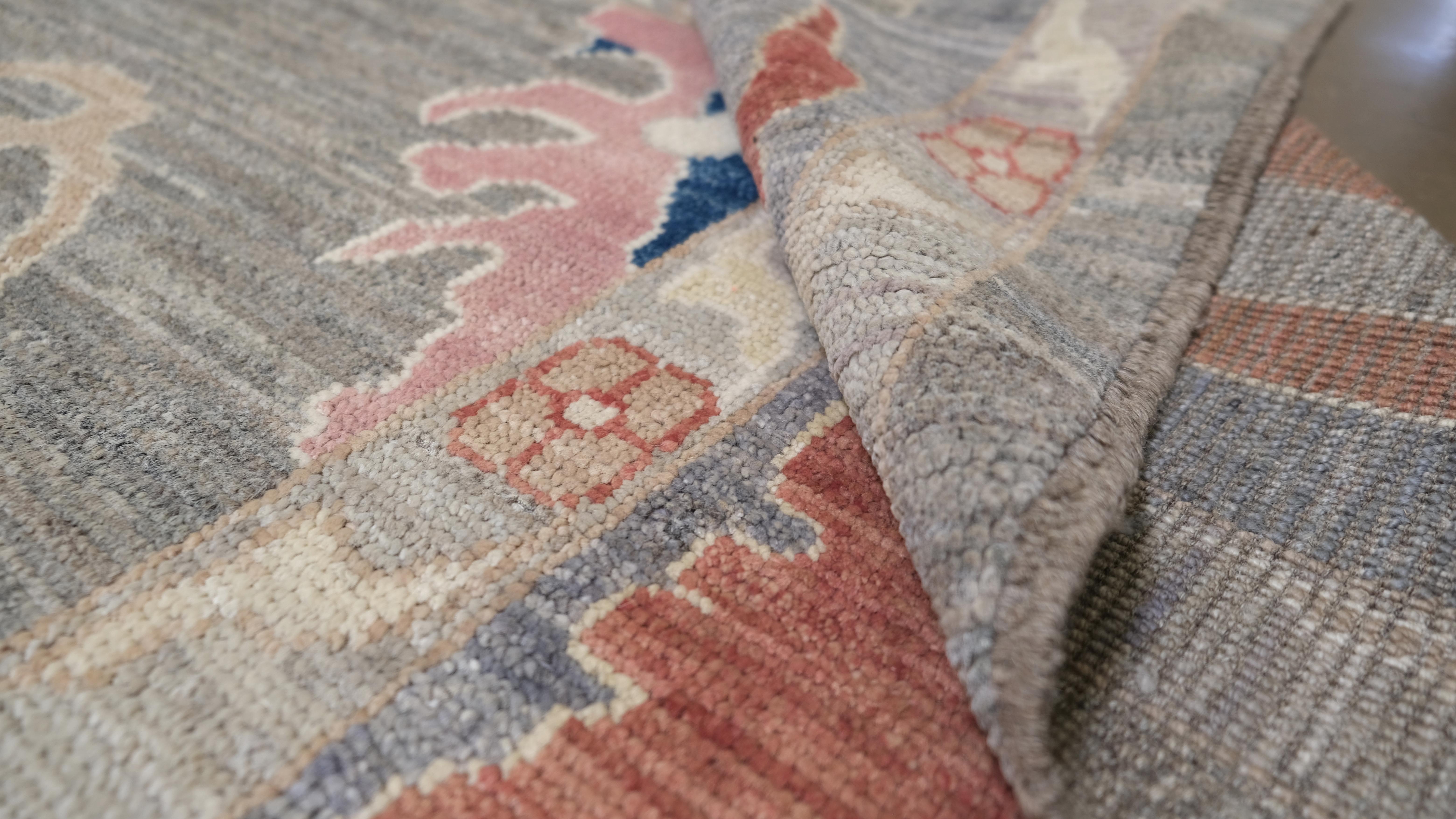 Dieser exquisite, handgeknüpfte Wollteppich mit einer harmonischen Mischung aus traditionellen floralen und geometrischen Motiven wertet Ihre Einrichtung auf. Die weiche, mehrfarbige Palette, die von sanften Blau-, Rosa- und Cremetönen sowie