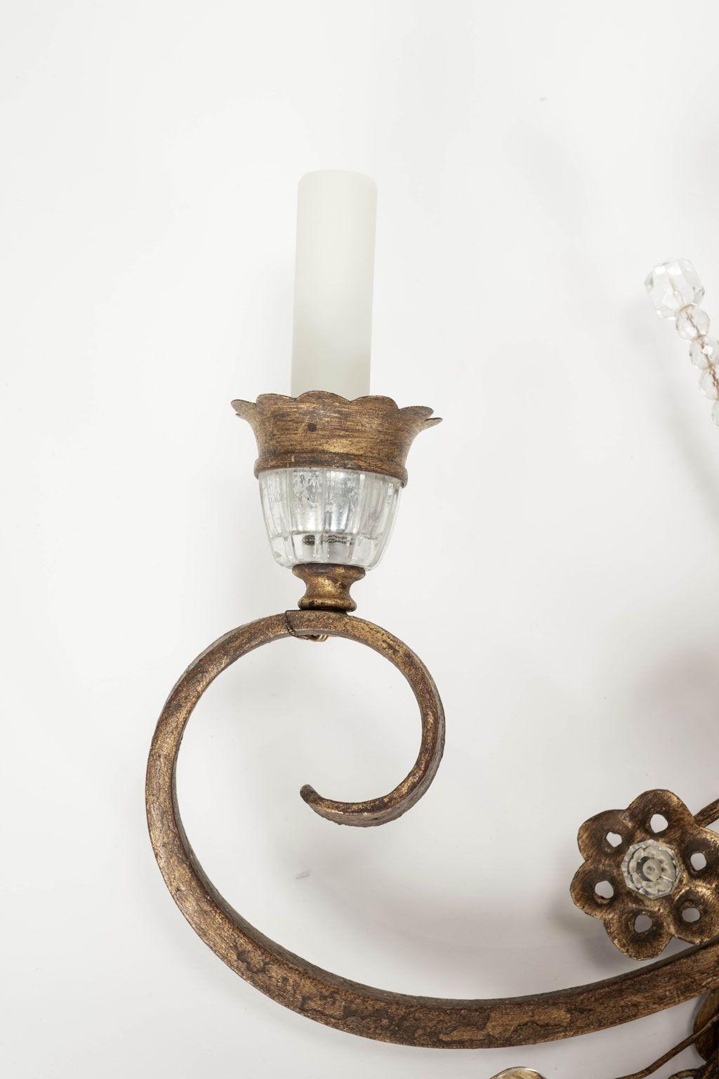 Large-scale pair of gilt-iron and crystal sconces circa 1960-1979. In the style of Maison Baguès. French gilt and silvered iron and crystal sconces newly wired for use within the USA using UL listed part. Sold together and priced $9,800 for the pair.