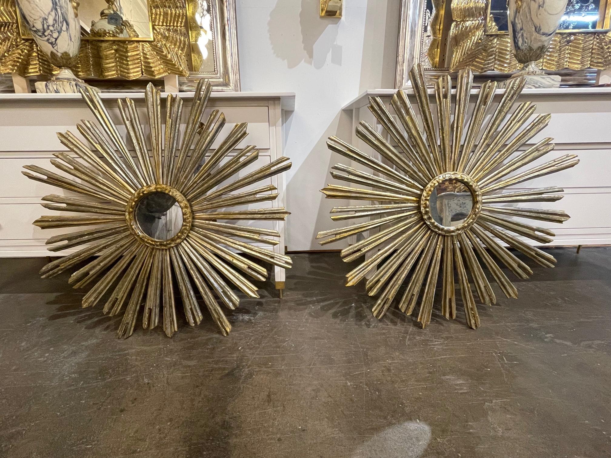 Large scale pair of Italian carved silver and gold sunbursts with a mirror in the center. A beautiful decorative element that makes a huge impact! Gorgeous!