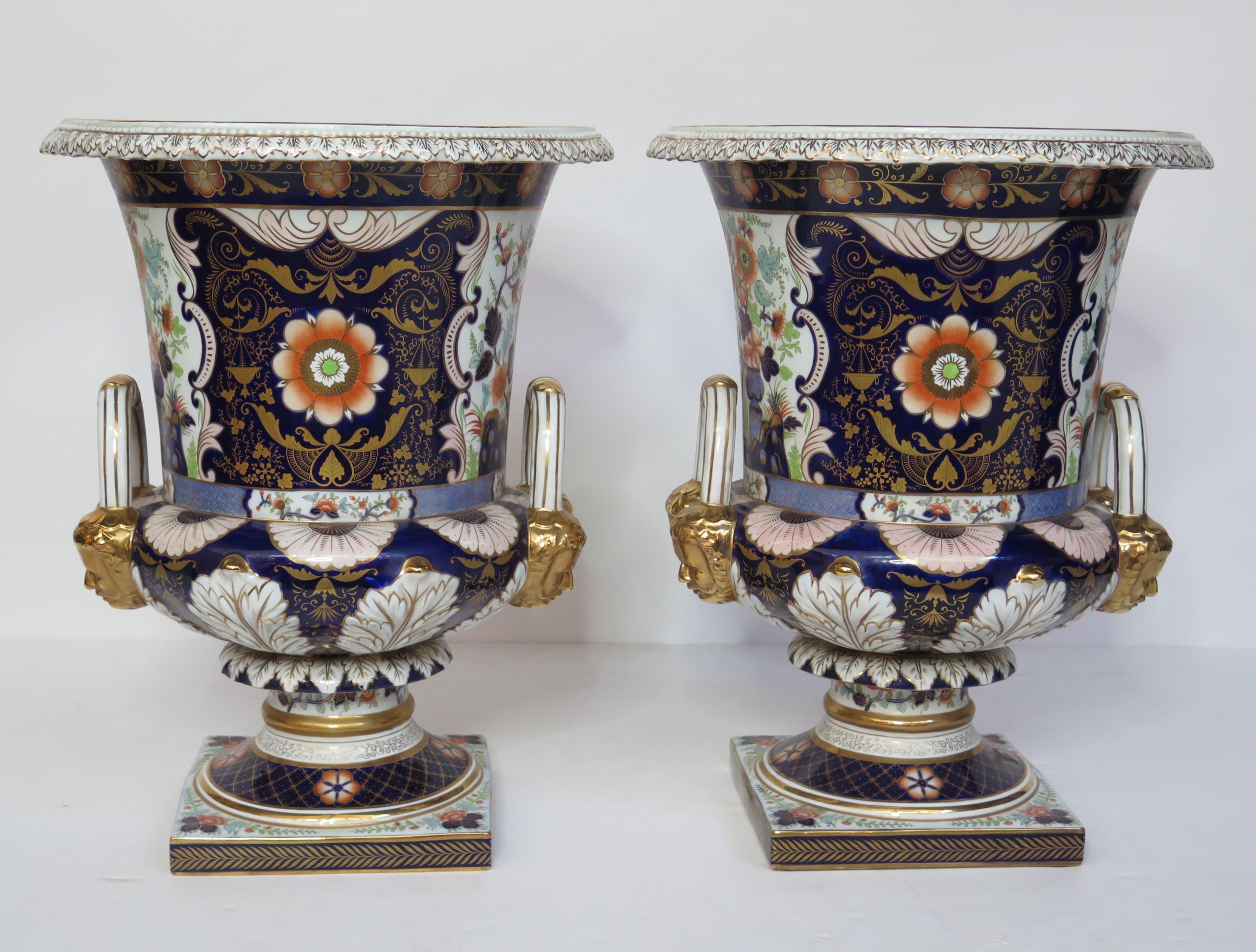 A gorgeous pair of large scale Royal Crown Derby style campana urns. At over two feet high, they're an impressive size with gorgeous designs hand painted onto every surface of the porcelain.
Incredibly detailed and intricate, particularly the gold