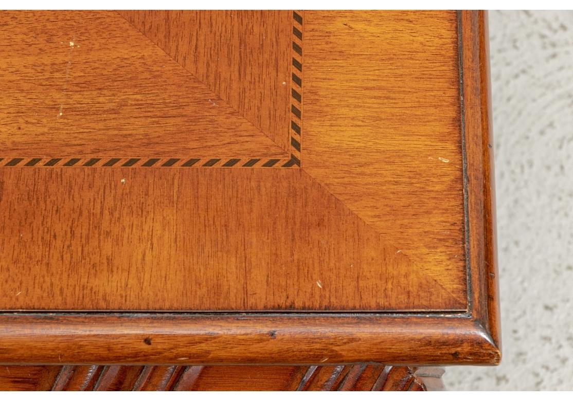Fine construction with a banded book matched top in a diamond pattern with herringbone string inlay. The deep apron carved in a curved ribbed pattern with beaded lower edge. Raised on massive carved bun feet. 

Dimensions: 44 x 44