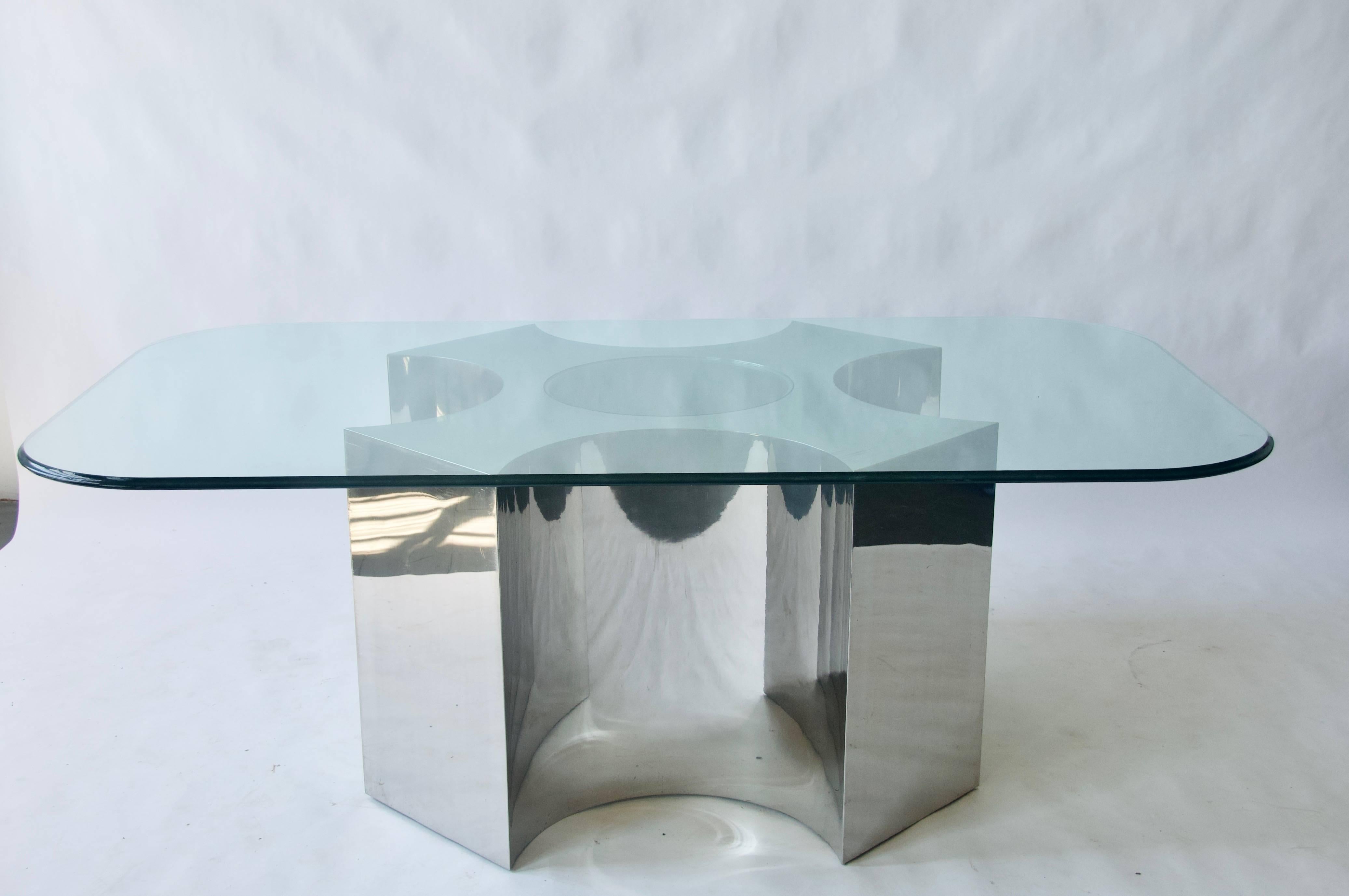 Rare large-scale polished steel table. Polished base has a glass inset on the top. This table base can hold a much a much larger top than the one that is pictured. The glass top pictured measures 48 x 84. 

The glass top is pictured for scale and
