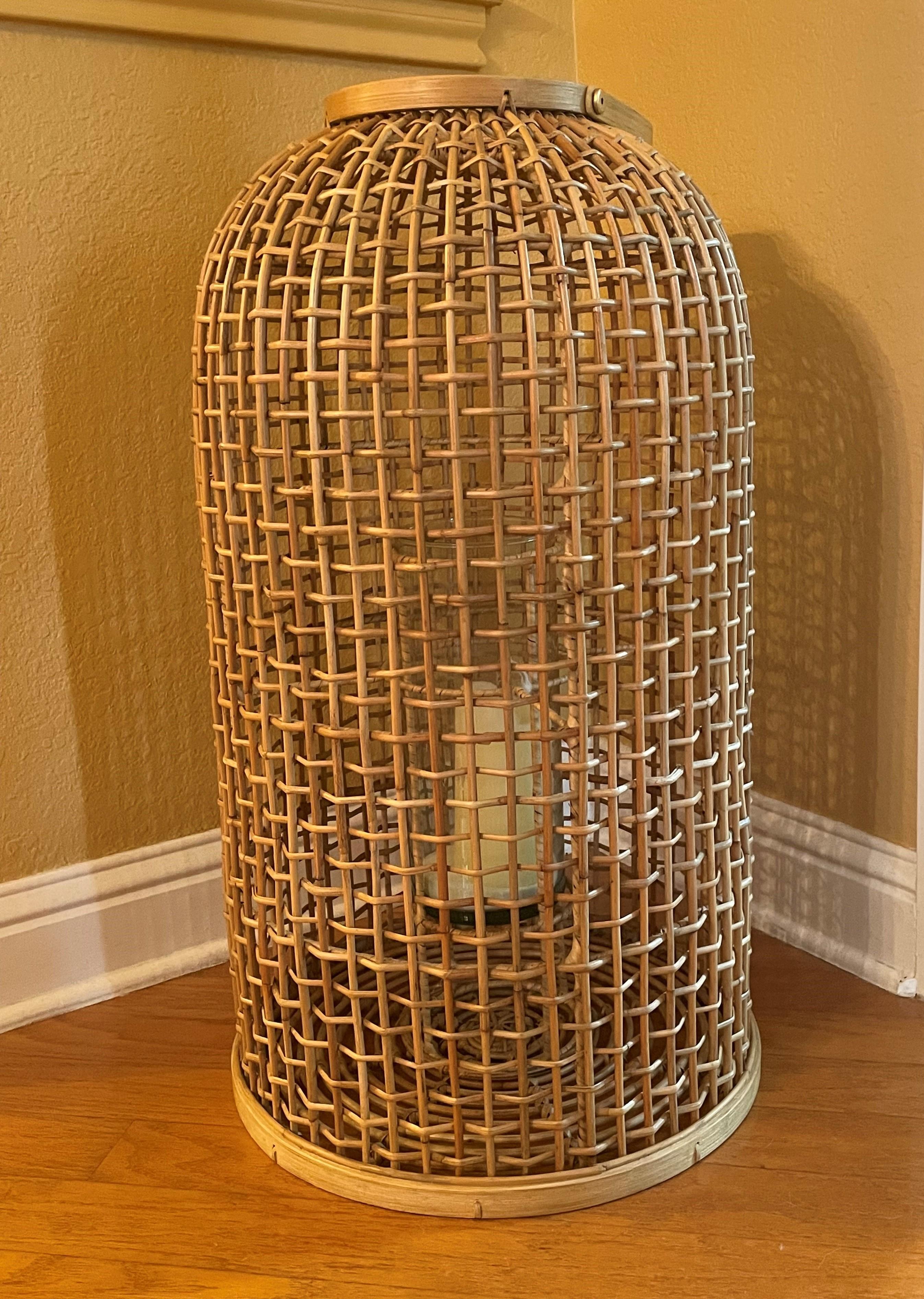 A wonderfully uncommon large-scale rattan floor lantern for indoors or out! It's a timeless piece with a modern flare that mixes well with most any interior vernacular. It's easily movable from room to room or from indoors to out. The handle