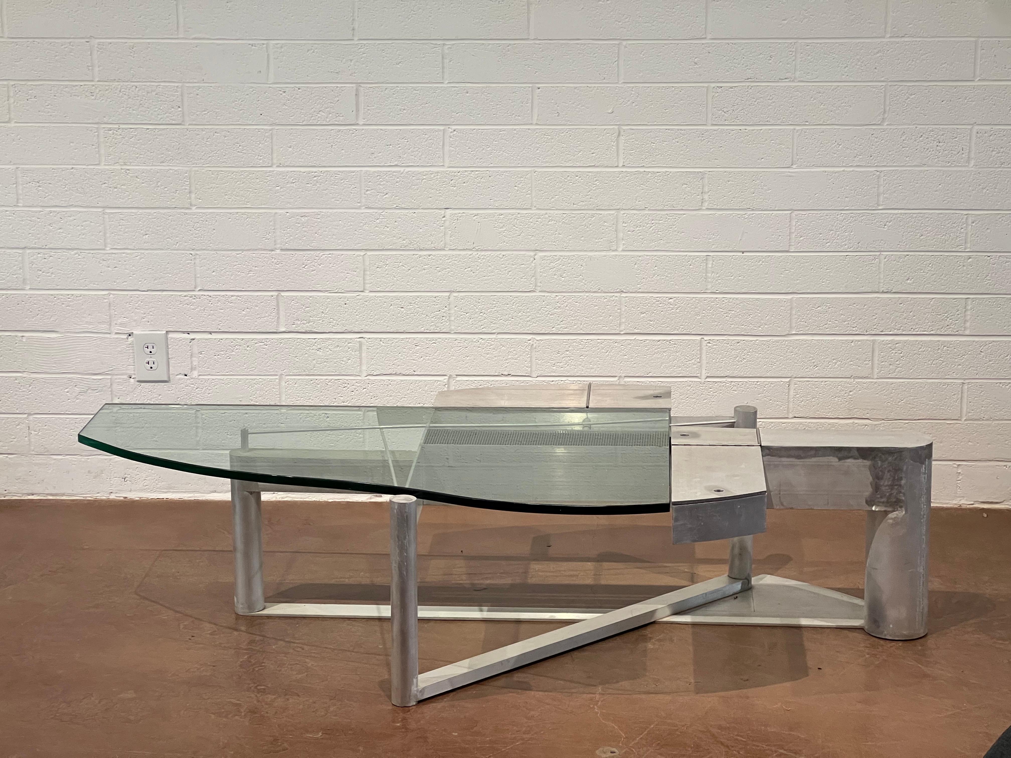This large-scale coffee table, designed by the esteemed architect Robert Whitton, is a stunning example of craftsmanship and design excellence from the late 20th century. Constructed from aluminum and glass, the table showcases a perfect balance of